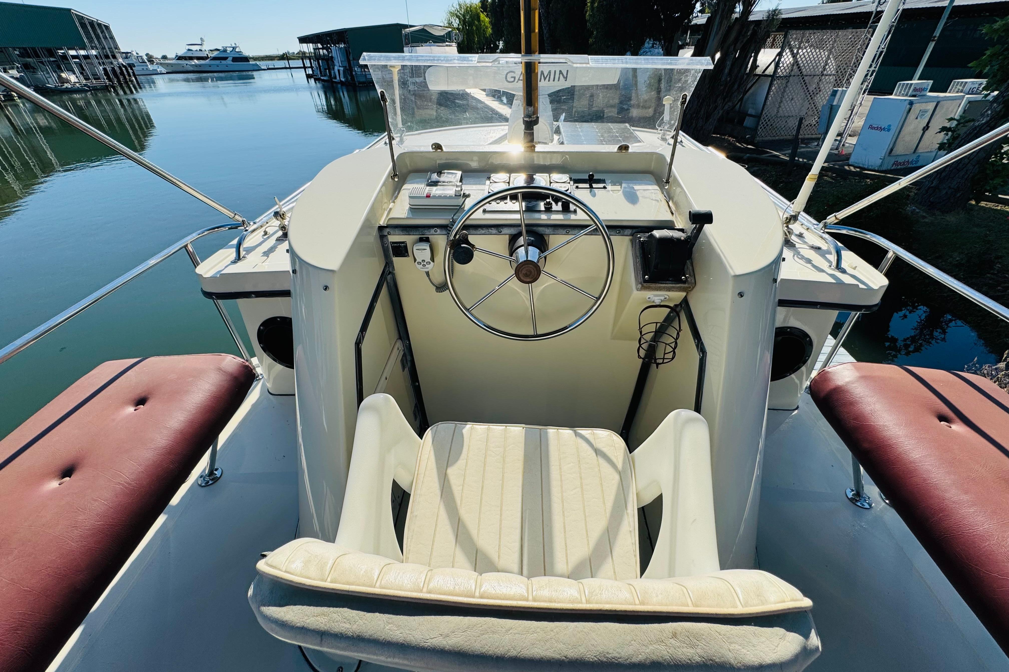 Cockpit of a 1996 Nordic Tug 32 boat with steering wheel and navigation equipment.