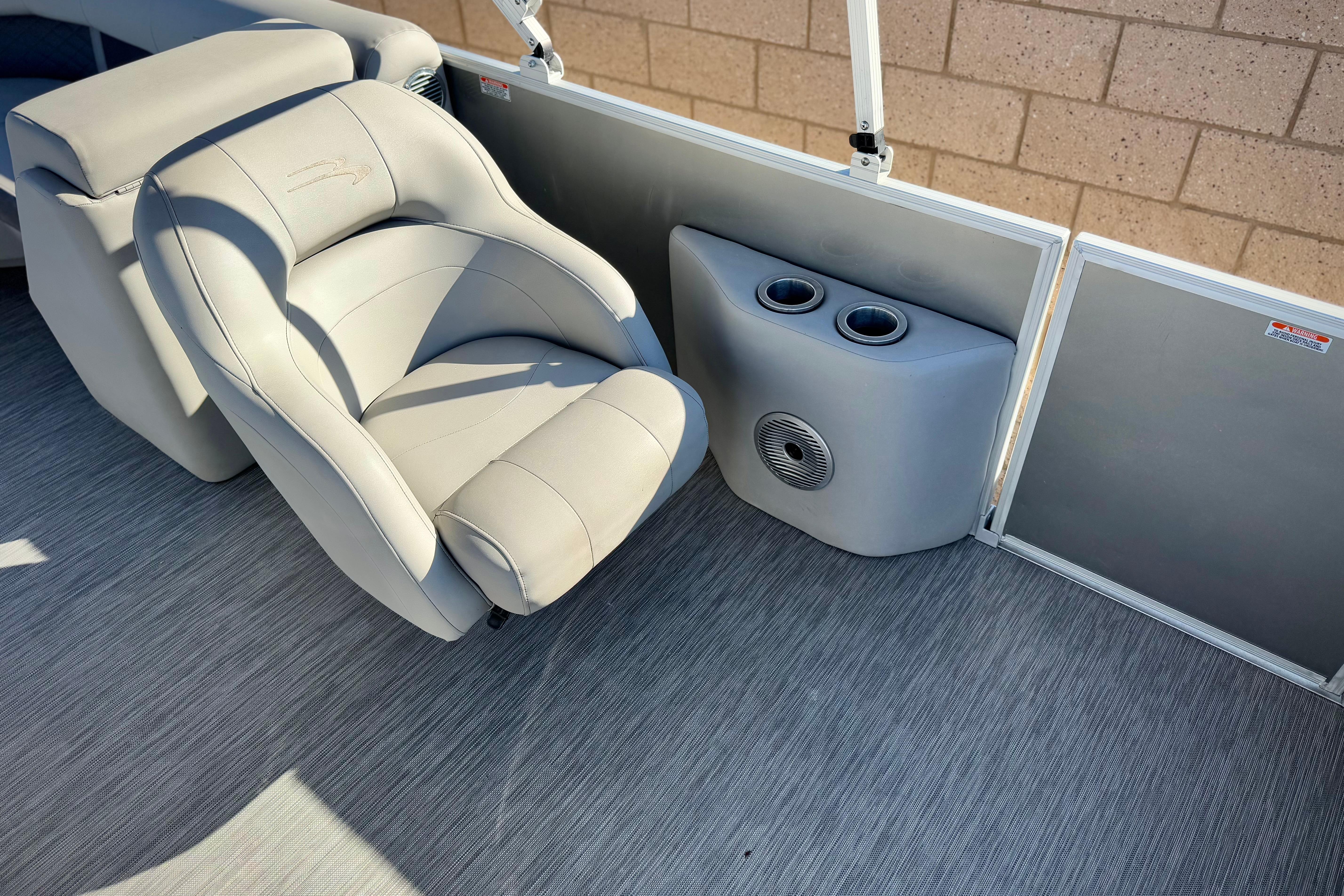 Luxurious seating on 2021 Bennington 23LSR boat with cup holders and speaker.