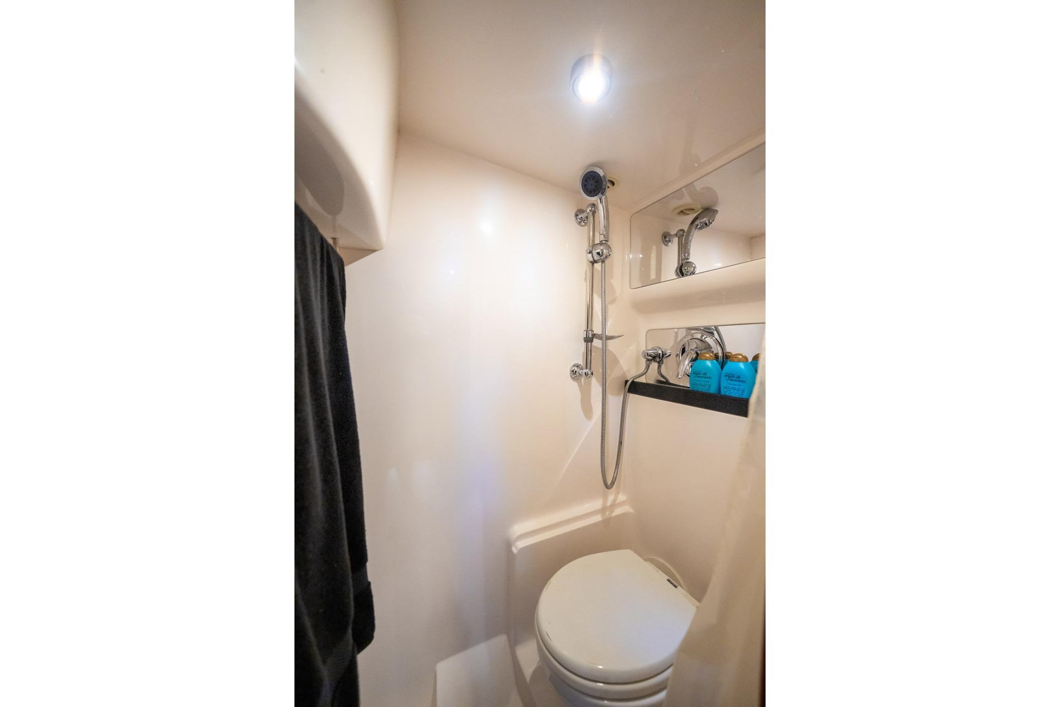 Compact bathroom in 2008 Regal Commodore 4460 yacht with shower and toilet.