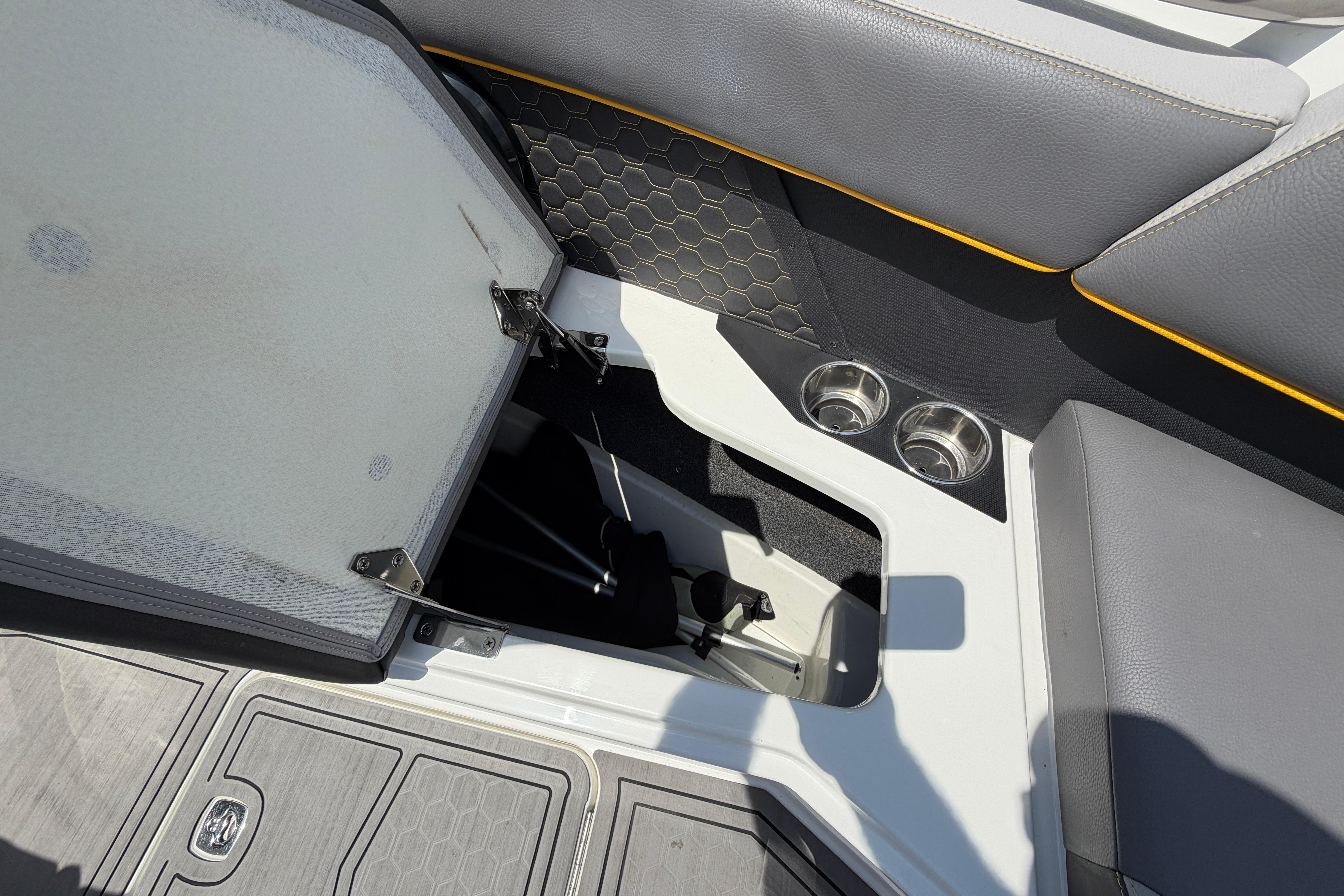 Interior view of a Cobalt R8 Surf boat with storage compartment and cup holders.