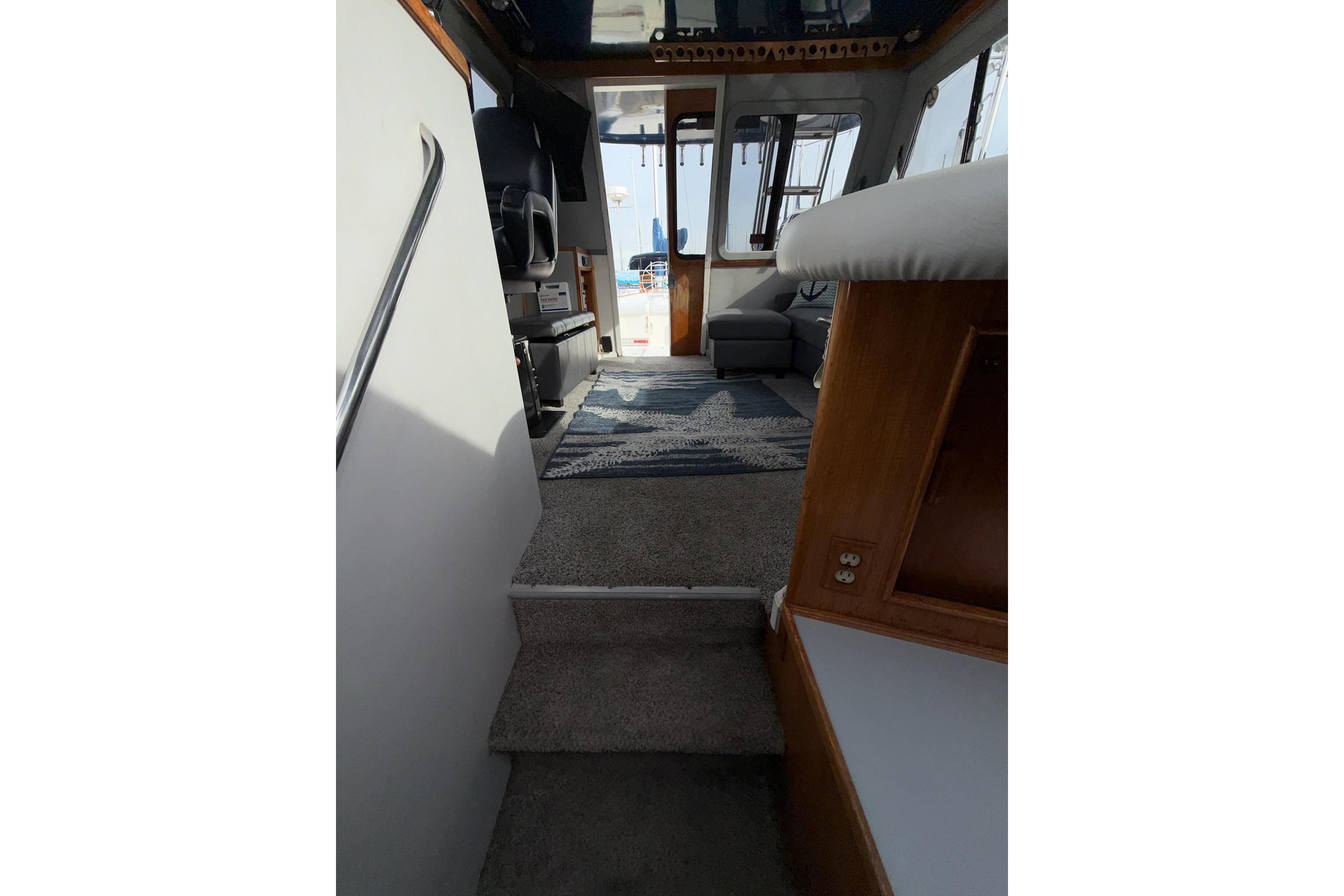 Interior view of a 1990 Mediterranean Sport Fish boat, featuring carpeted steps and seating area.