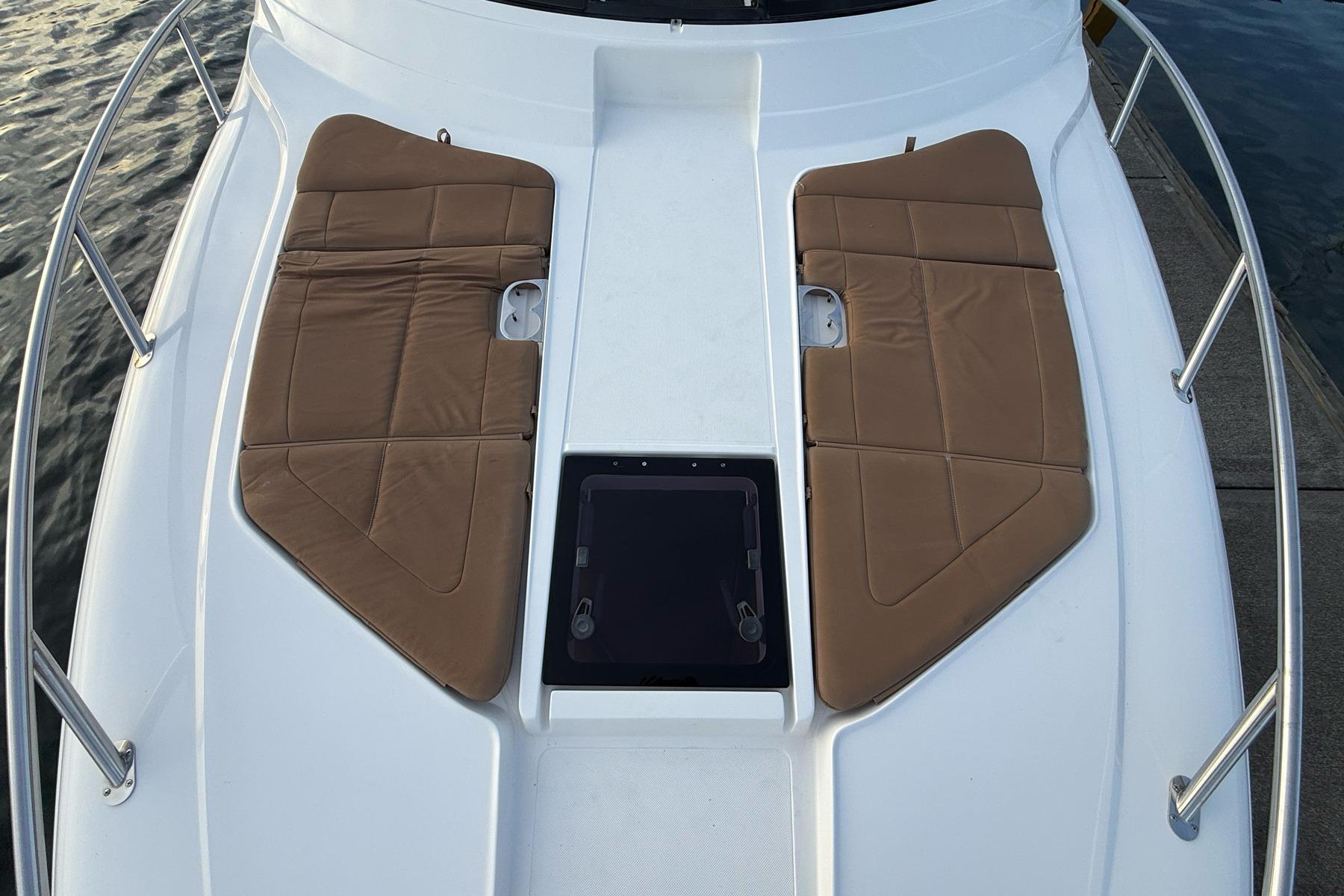 2017 Cobalt A40 Coupe boat deck with brown cushioned seating and railing.