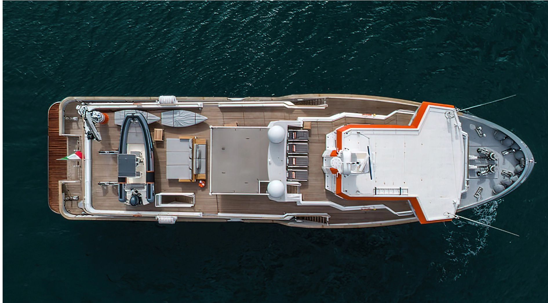 Aerial view of a luxury yacht on the water with spacious deck and tender.
