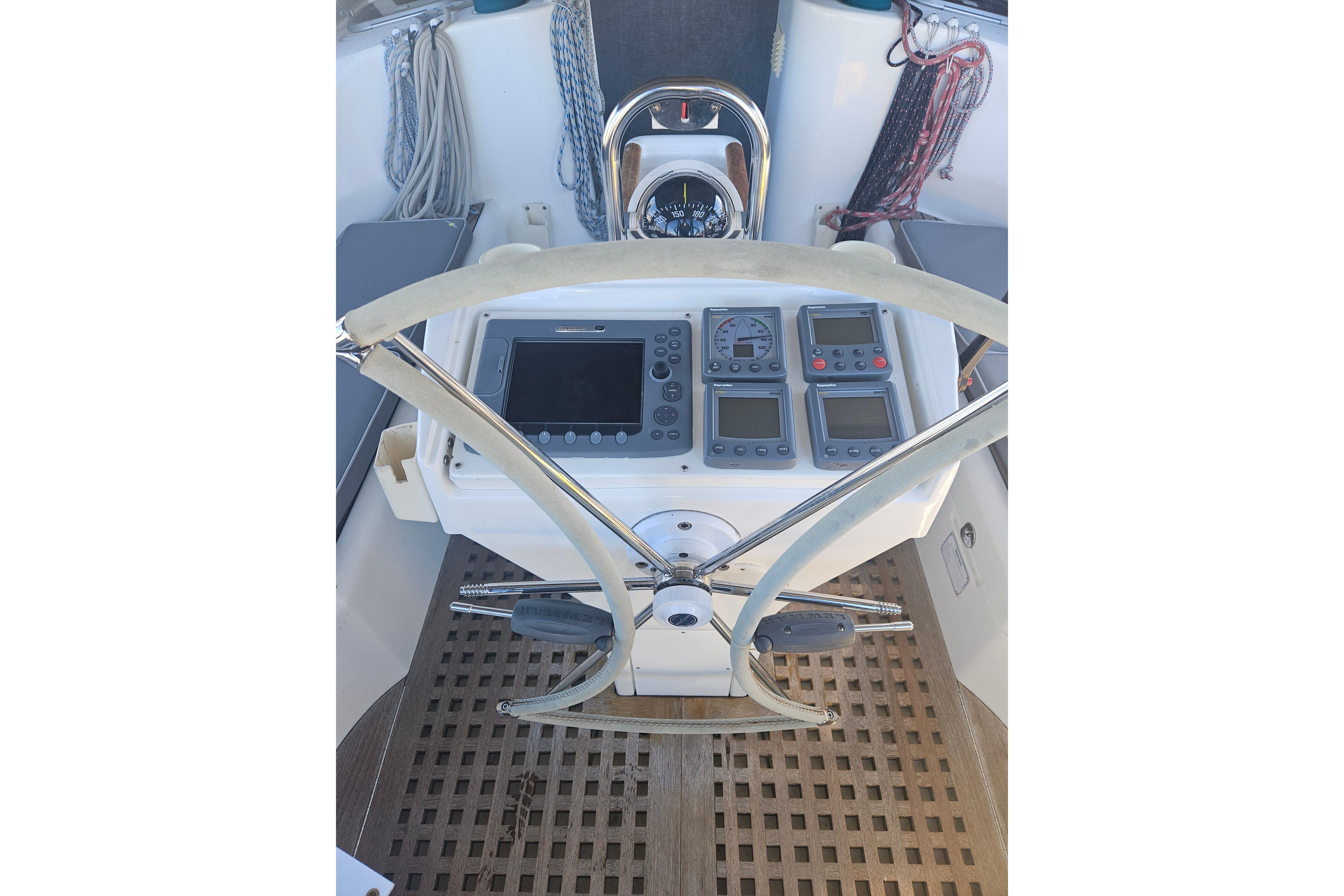 Cockpit of 1998 Beneteau 381 sailboat with navigation instruments and steering wheel.
