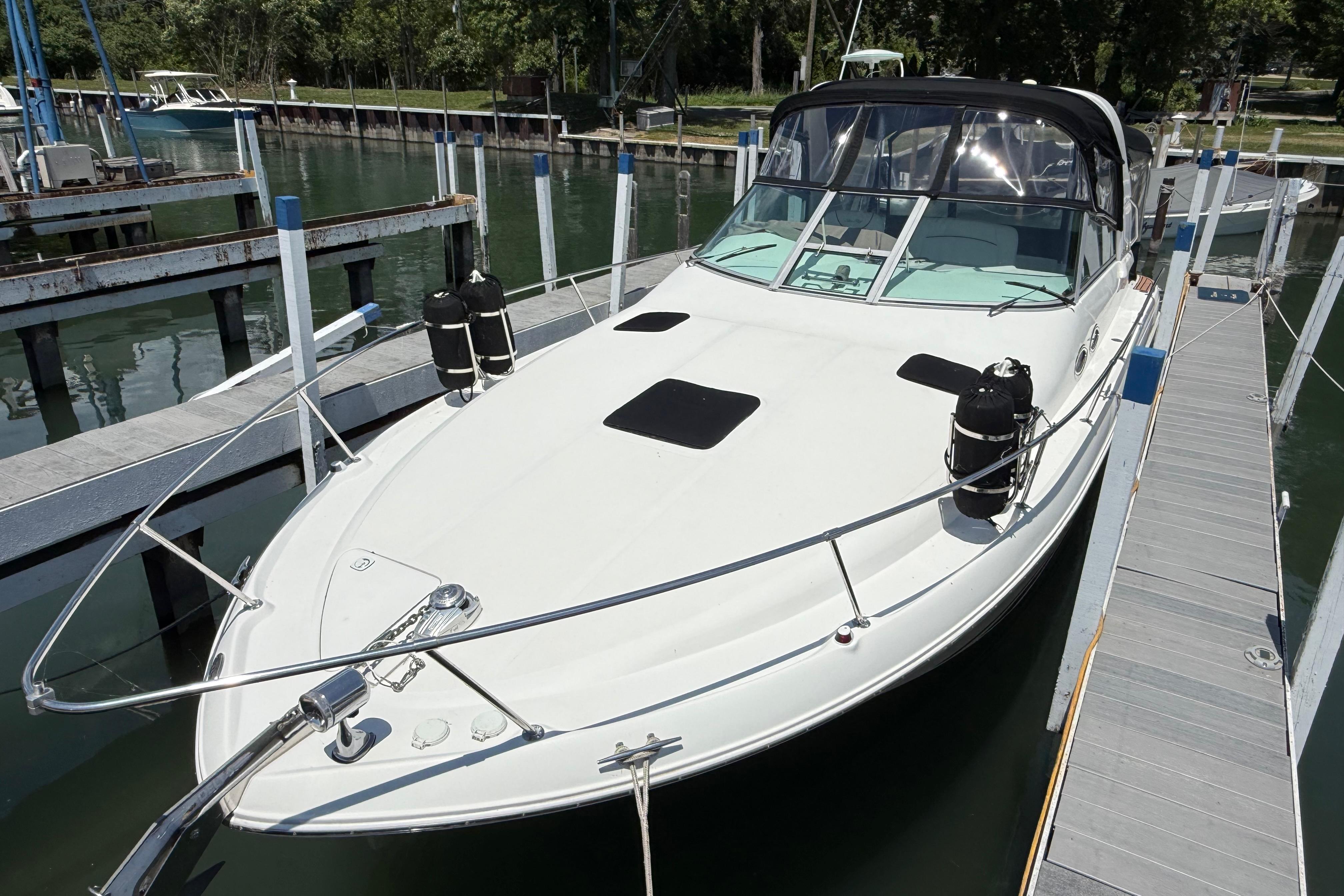 1999 Sea Ray Sundancer 310 docked at marina, featuring sleek design and spacious deck.