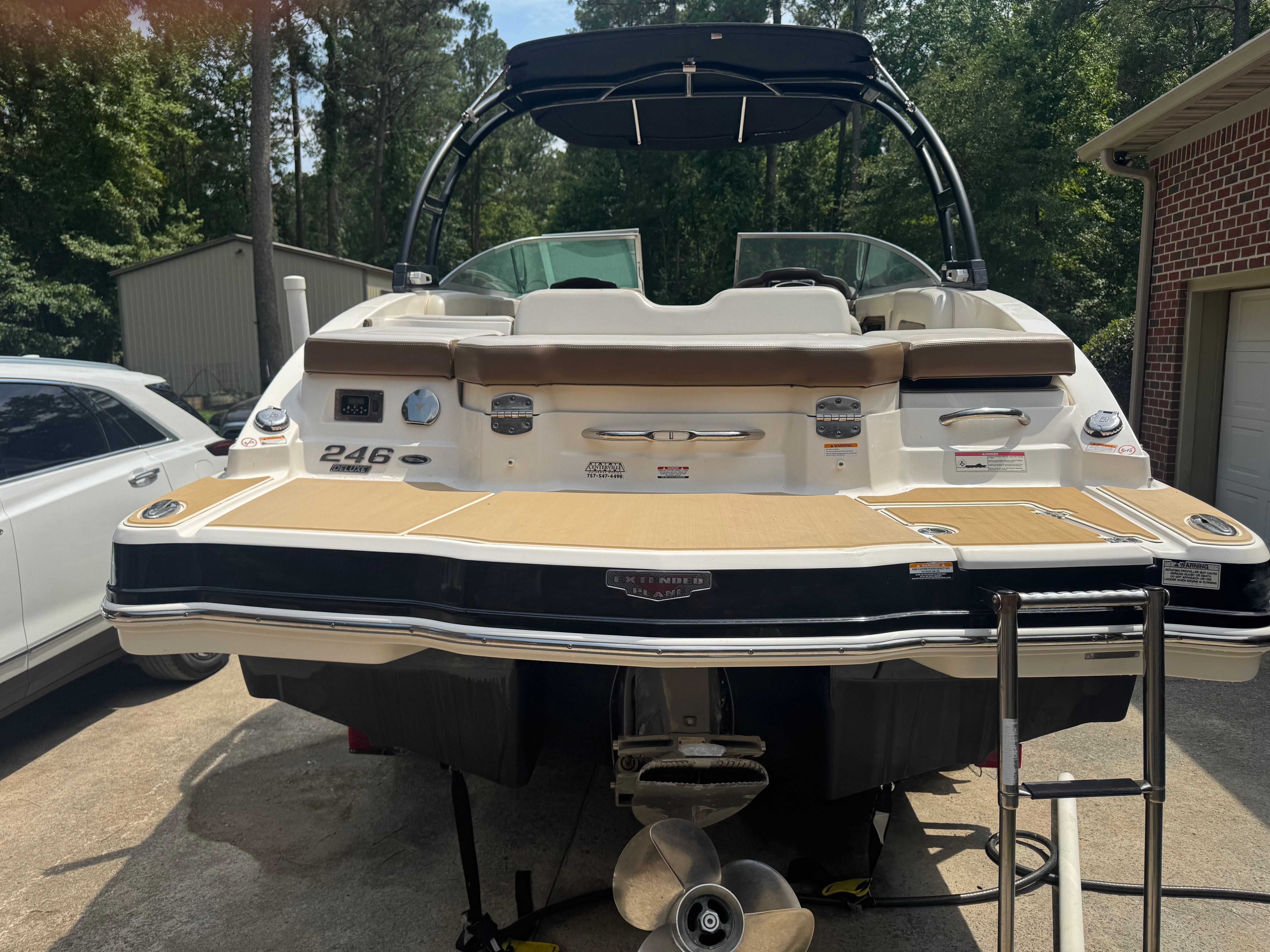 2016 Chaparral 246 SSi boat parked in a backyard.
