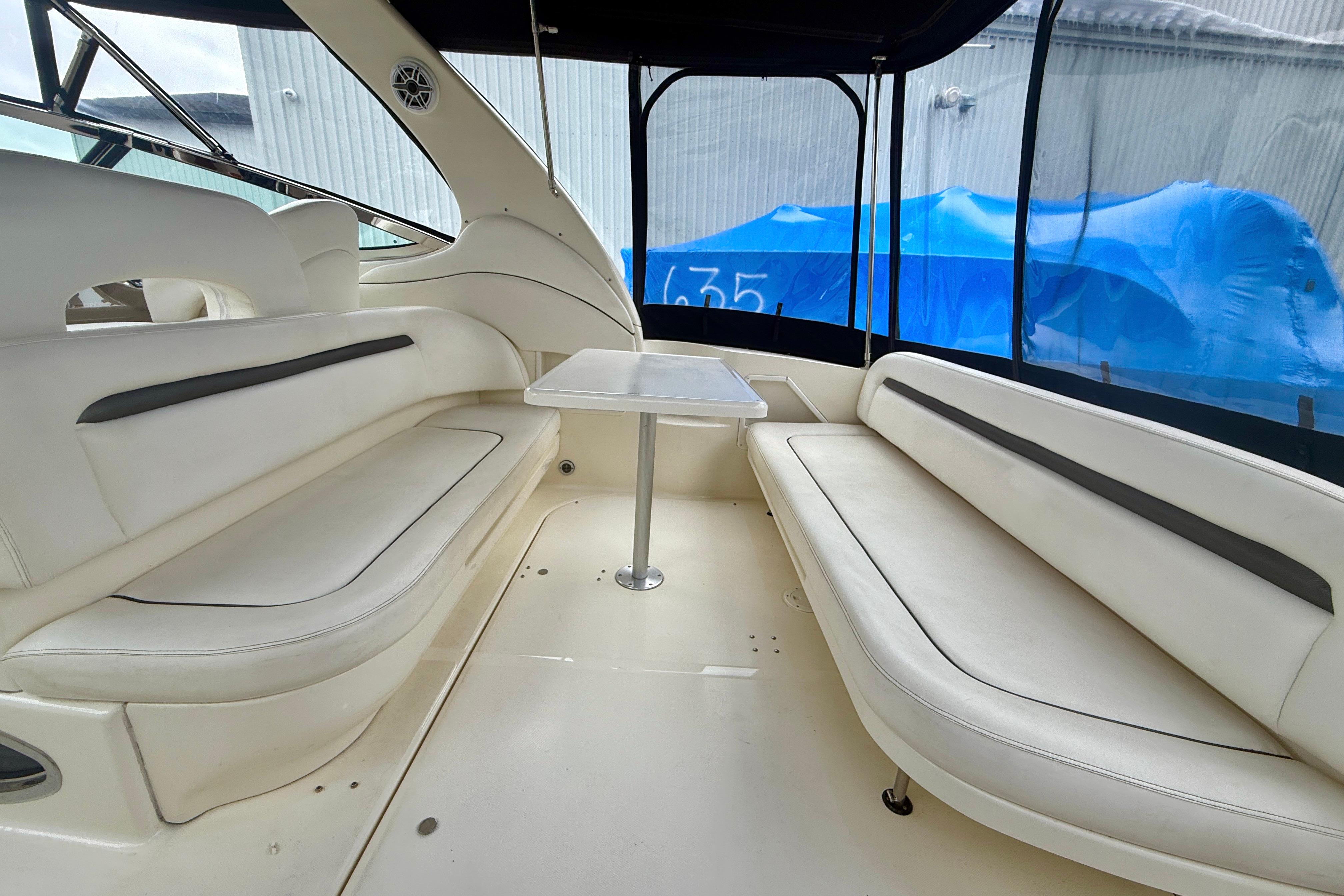 2004 Searay 360 Sundancer interior with white seating and table, enclosed cockpit.