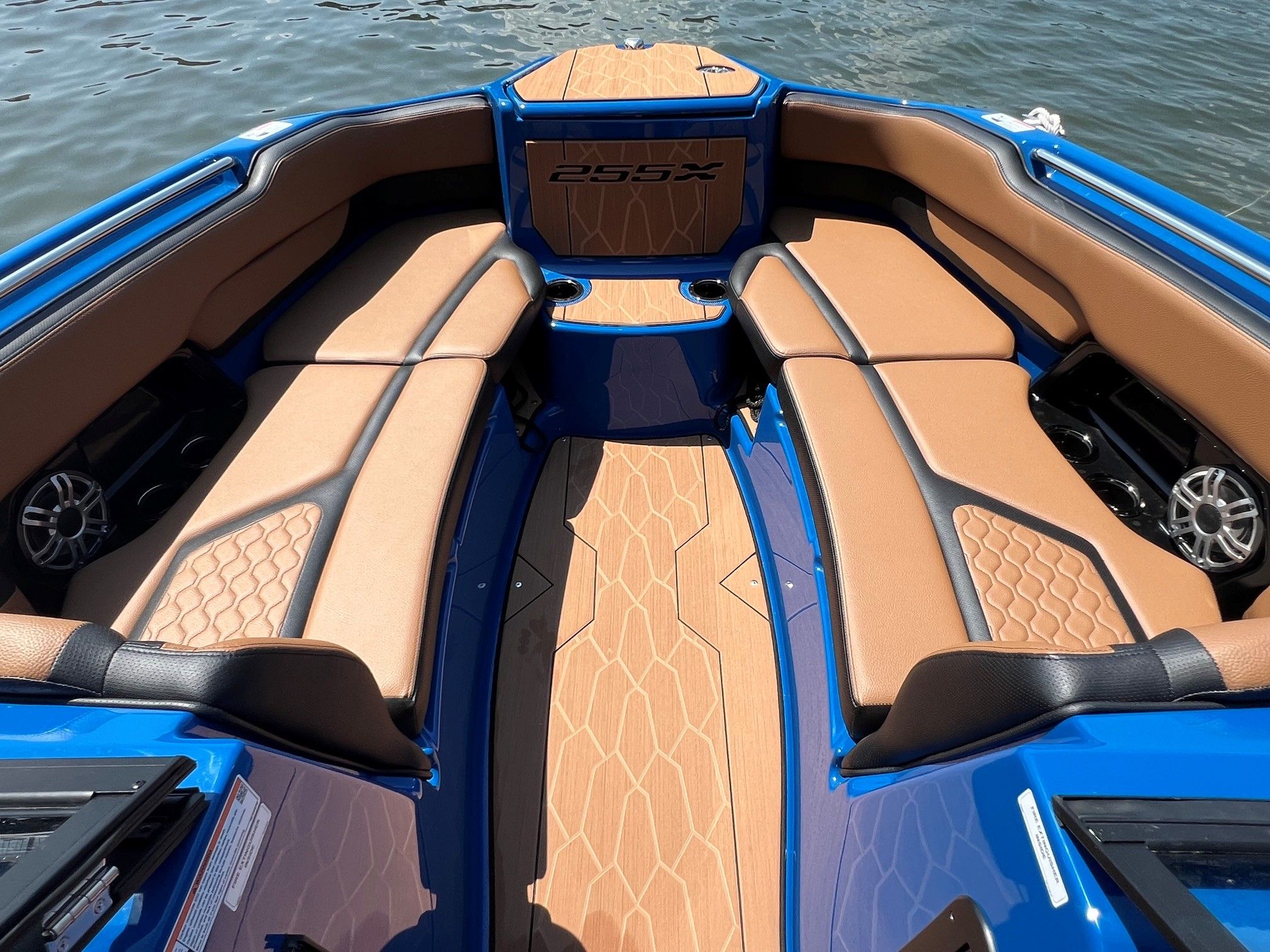 The image shows the bow of a blue Yamaha 255XD boat with brown upholstery.