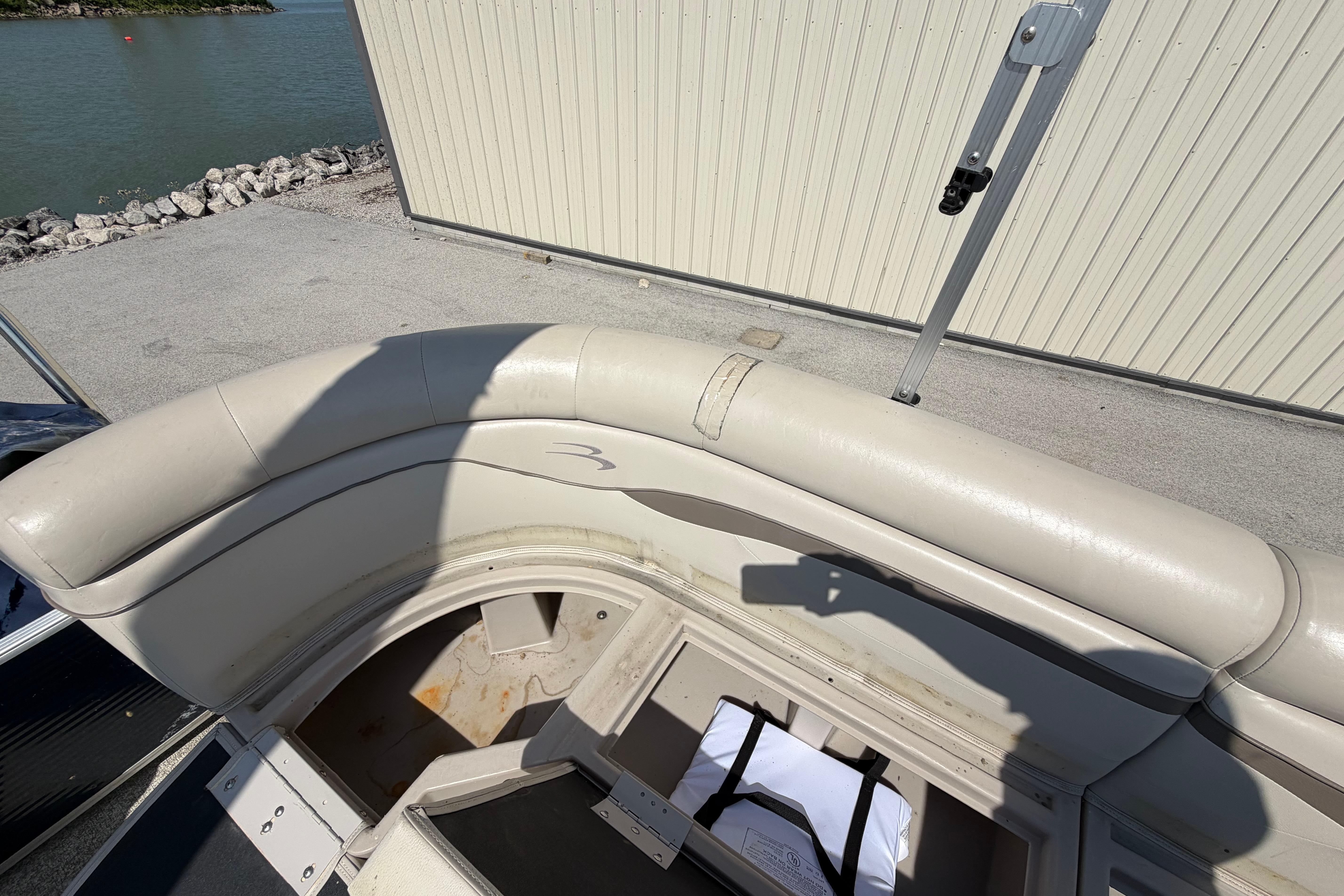 2017 Bennington 25 SSXAPG boat interior with beige seating and storage compartment.