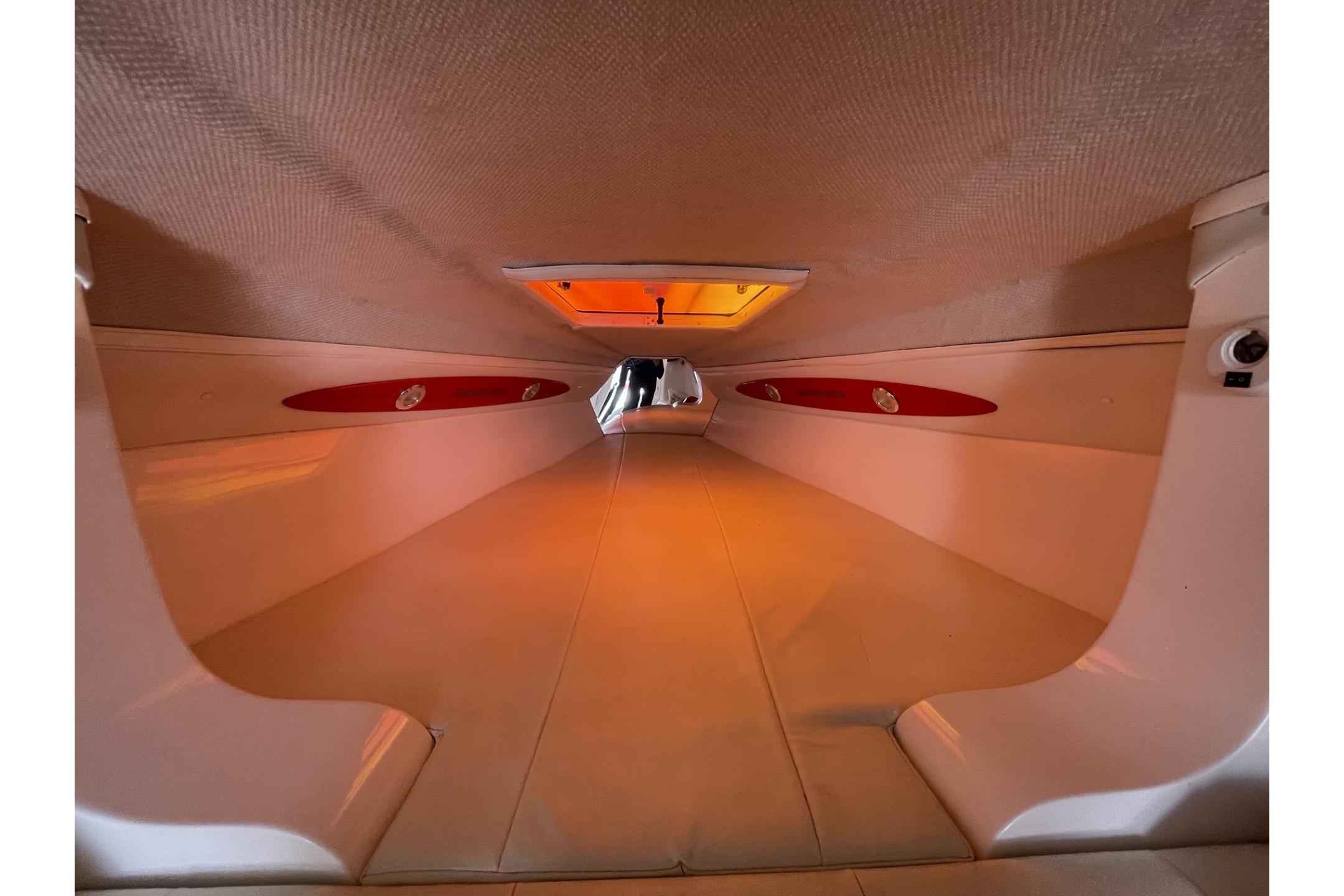 Interior view of a 2006 Sonic 386 boat cabin with orange lighting.