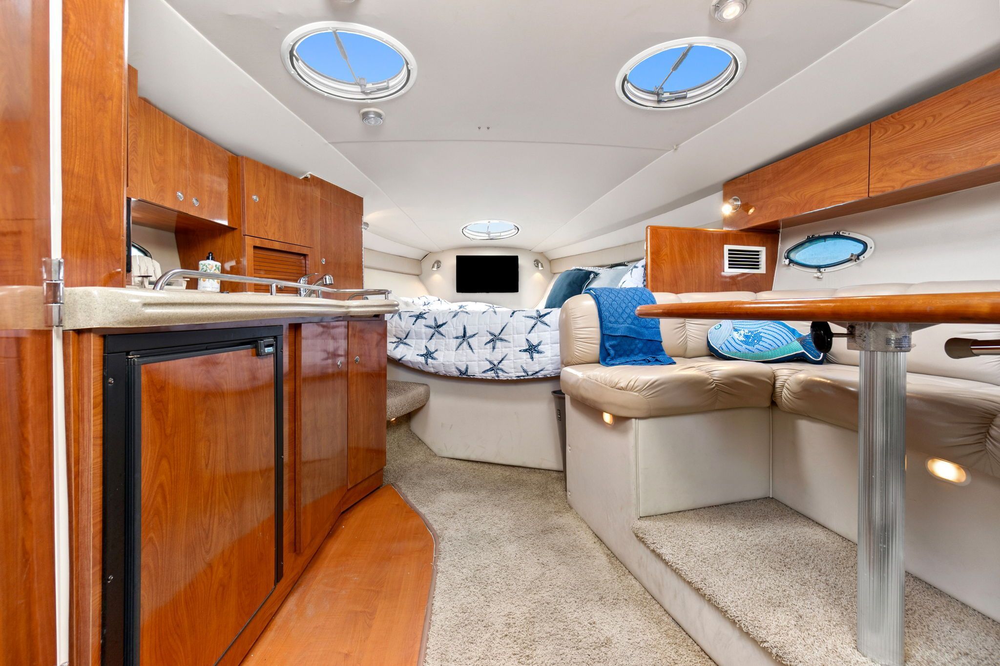 Interior of a 2007 Larson Cabrio 330 with kitchenette, seating area, and sleeping space.