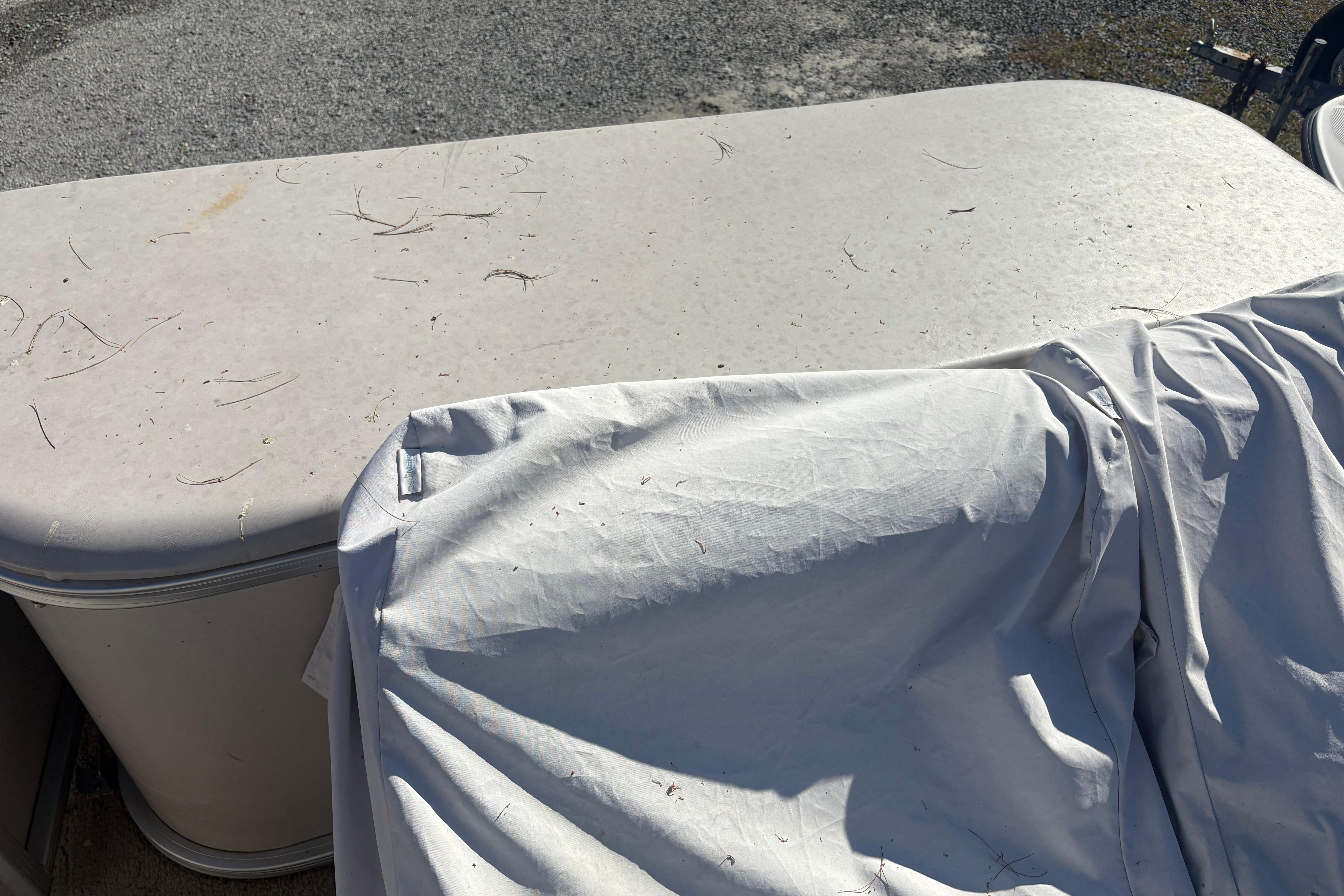 2003 Aqua Patio 200RE boat with cover, showing weathered surface and outdoor setting.