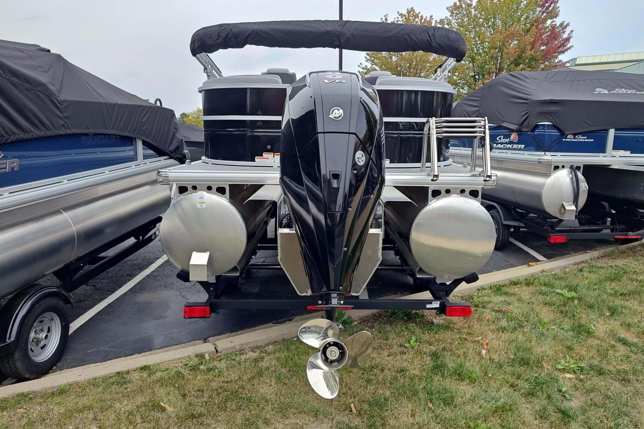 2026 Sun Tracker Party Barge 22 XP3 pontoon boat, rear view with motor, parked outdoors.