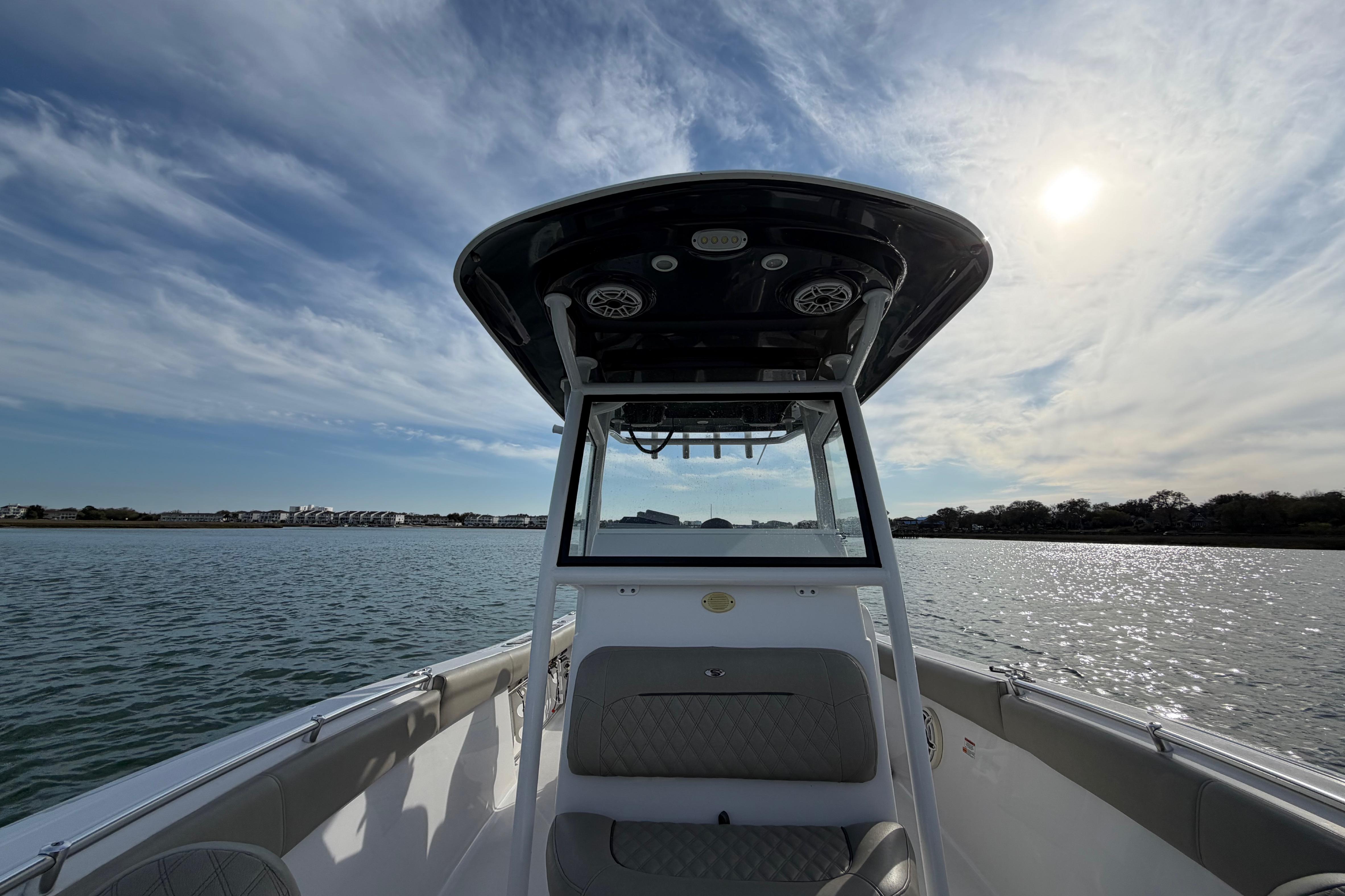 2021 Sportsman Heritage 251 Center Console boat on calm water under a sunny sky.