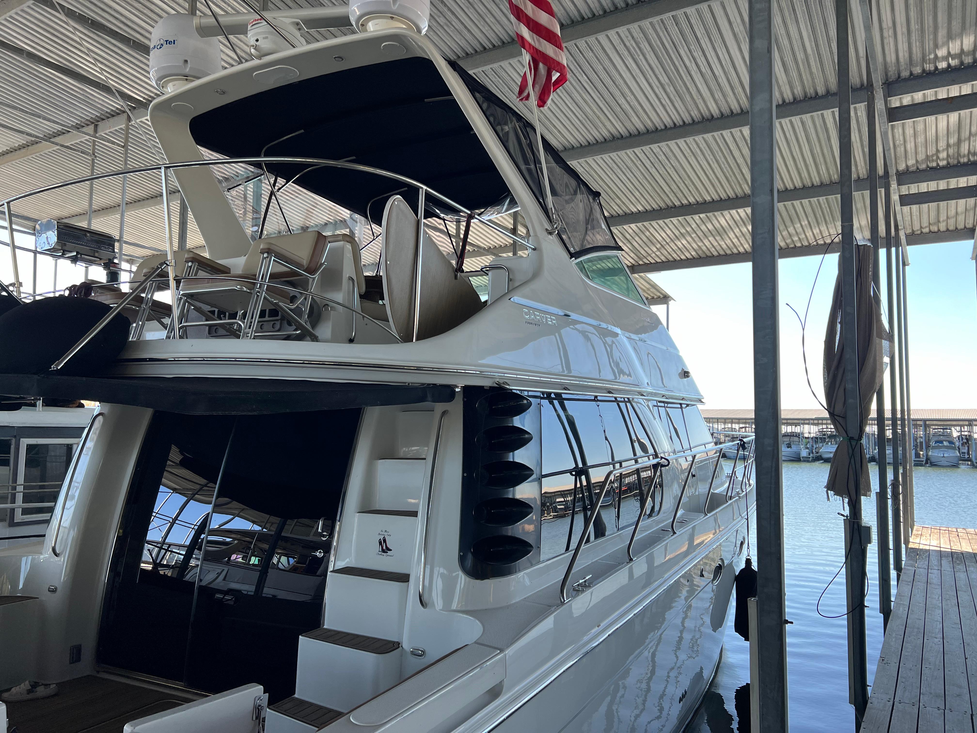 2001 Carver 450 Voyager Pilothouse yacht docked under a covered marina.