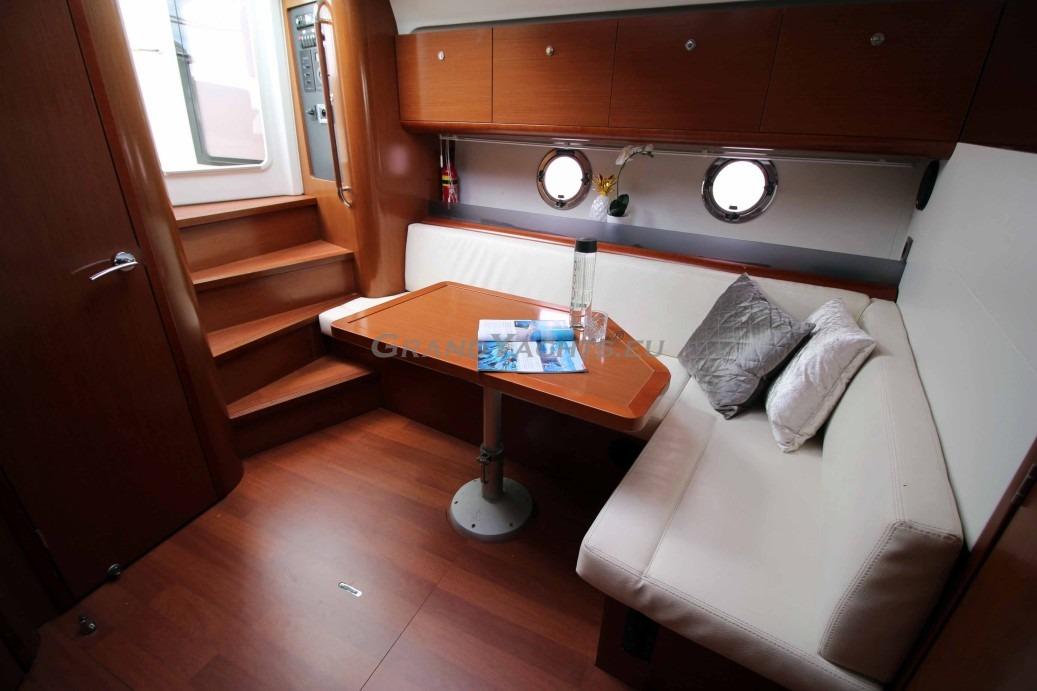 Interior of 2011 Beneteau Gran Turismo 38 yacht with cozy seating and wooden finishes.