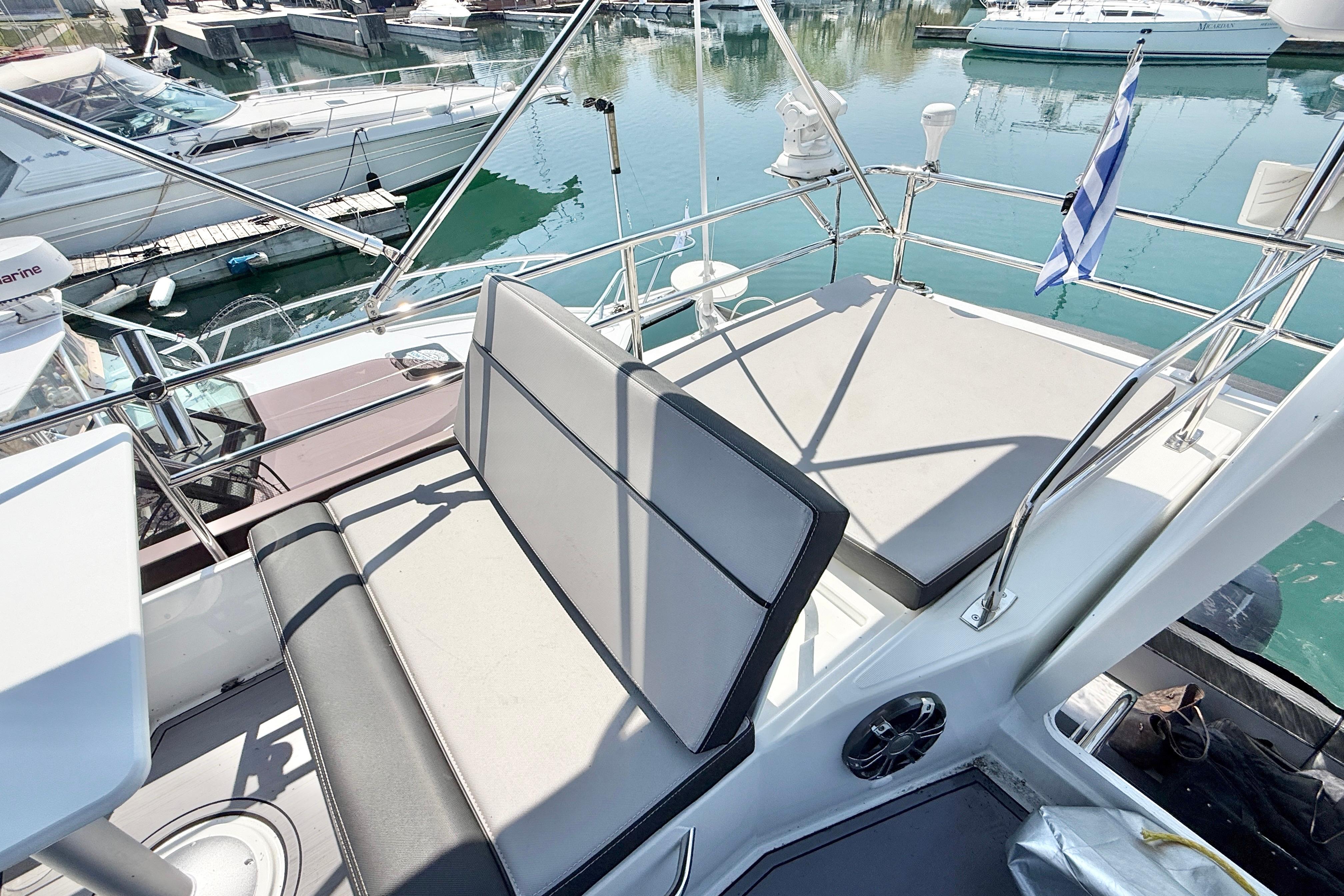 Flybridge of 2022 Jeanneau NC 1095 Fly yacht with seating and marina view.