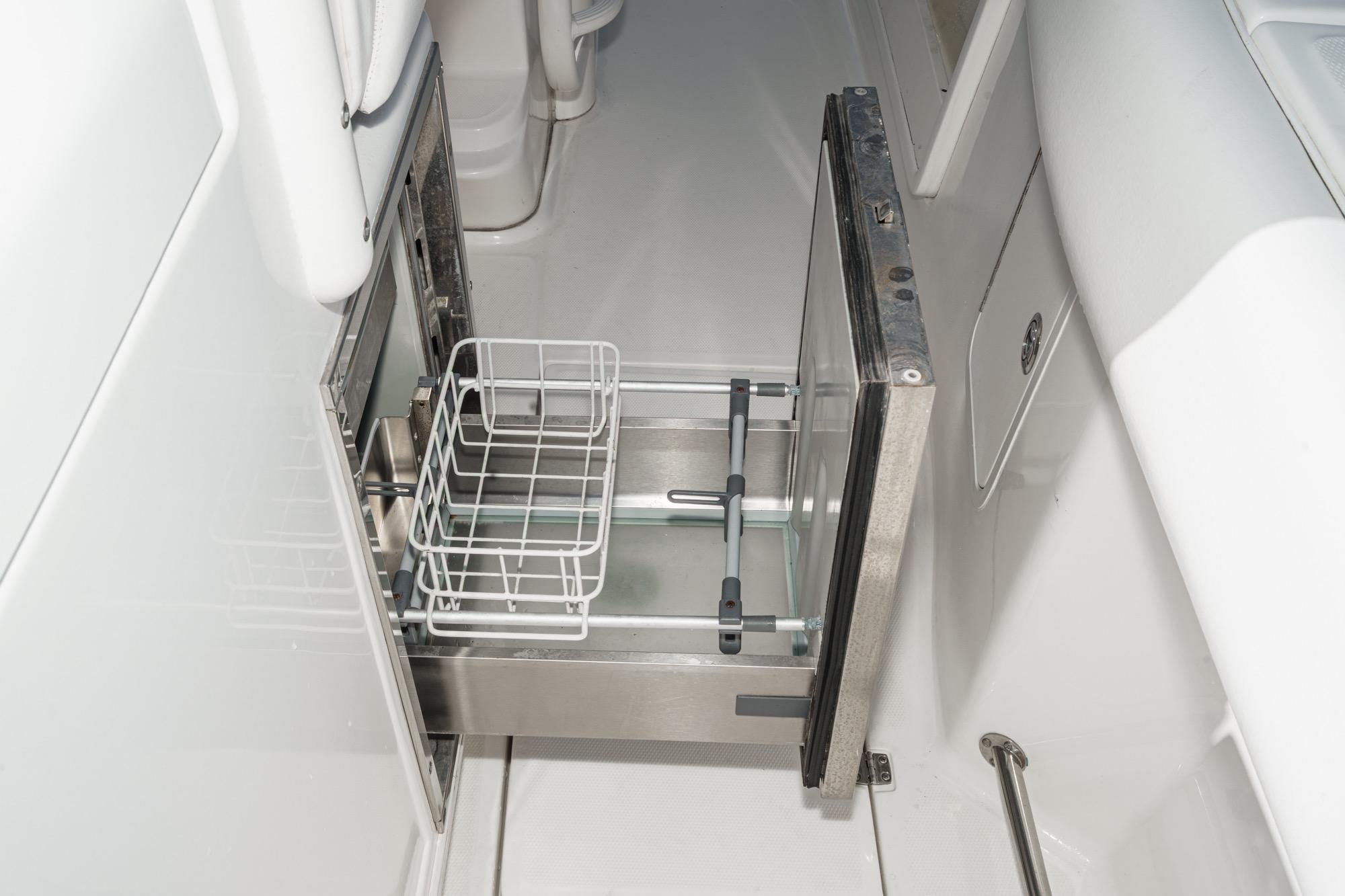 Open storage compartment on 2015 Boston Whaler 370 Outrage boat, featuring a wire basket.