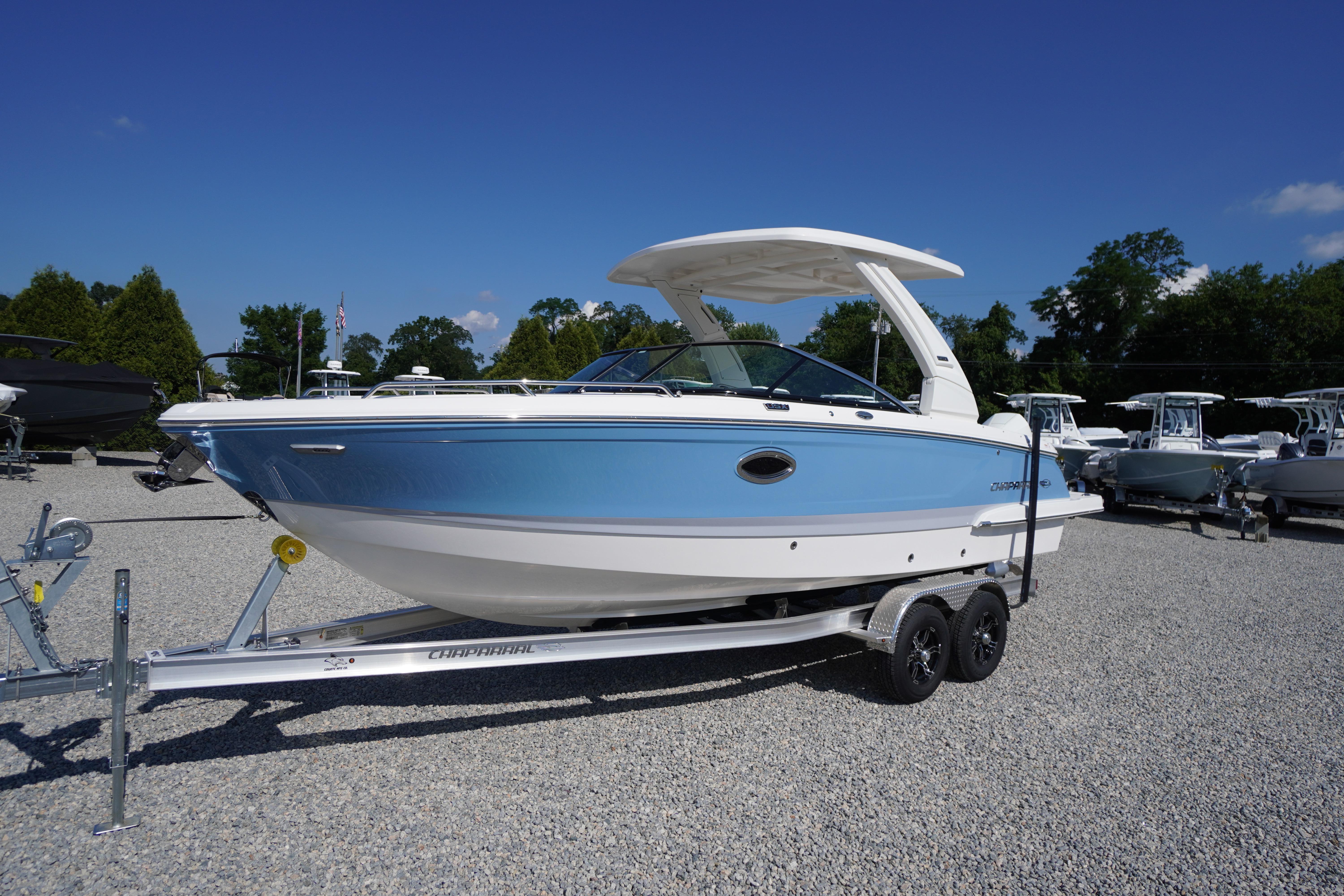 2026 Chaparral 270 OSX boat on trailer, displayed outdoors under clear blue sky.