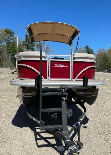 2025 Sun Tracker Party Barge 22 RF DLX pontoon boat on trailer, parked outdoors.