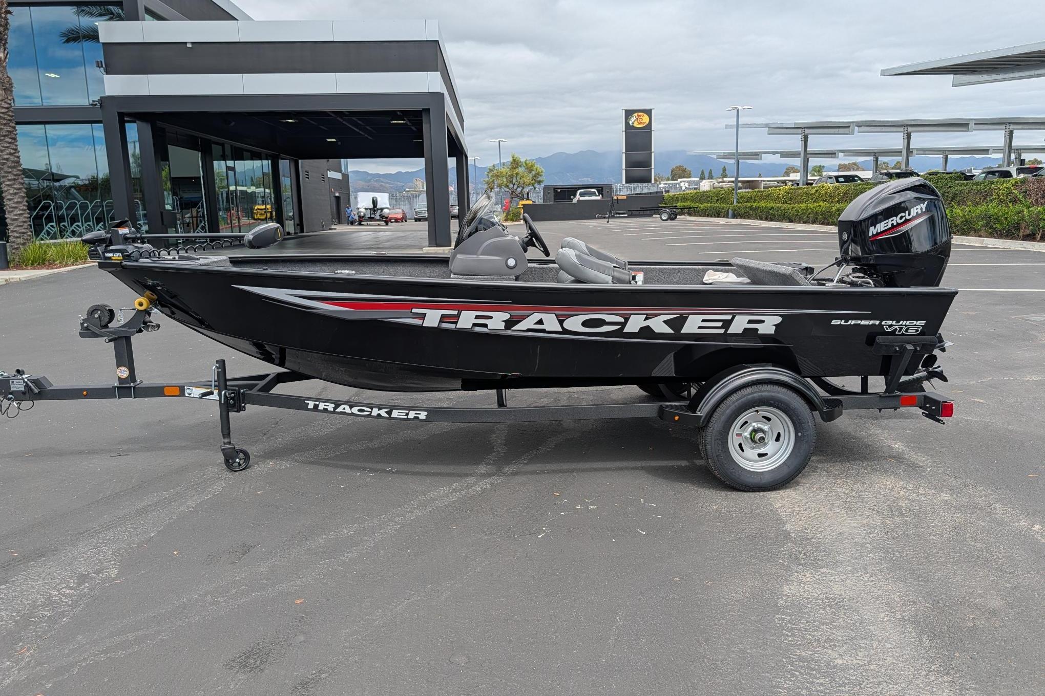 2026 Tracker Super Guide V-16 SC boat on trailer in parking lot.