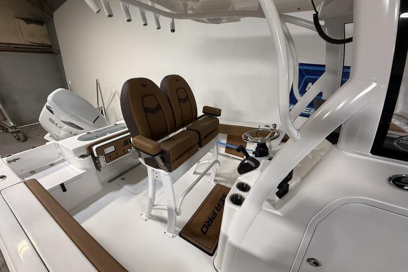 2026 Sea Pro 242 Center Console boat interior with dual brown seats and modern controls.