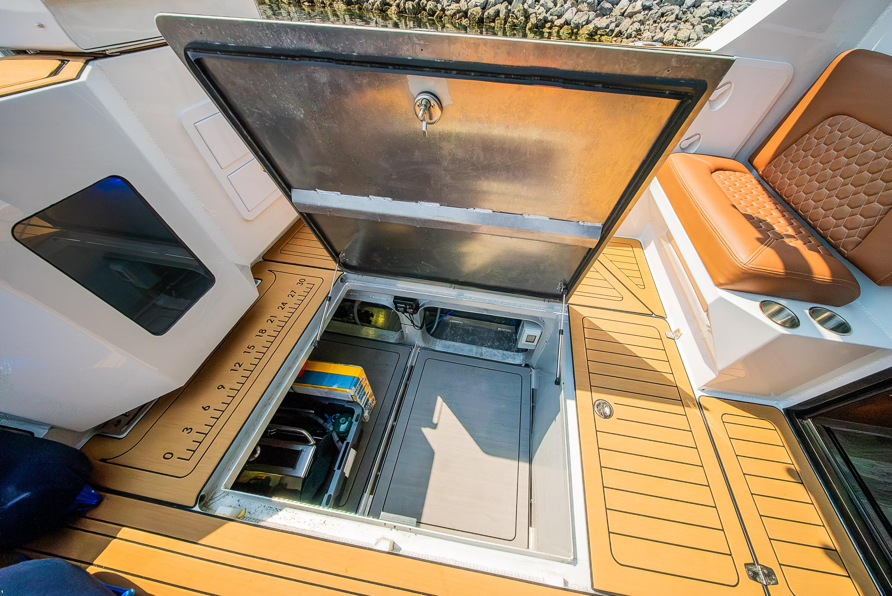 2024 Herley 11 Explorer boat storage compartment with open hatch and seating area.