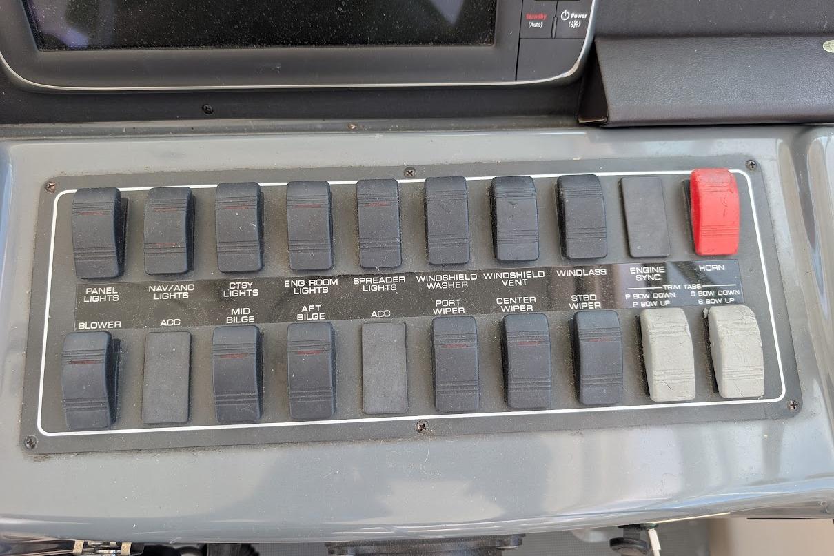 Control panel of a 2000 Pursuit 3400 Express boat with labeled switches.