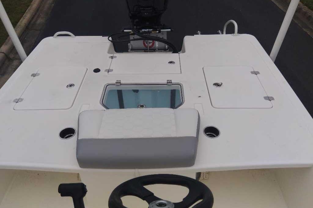 2026 Mako 18 Pro Skiff boat deck with storage compartments and steering wheel.