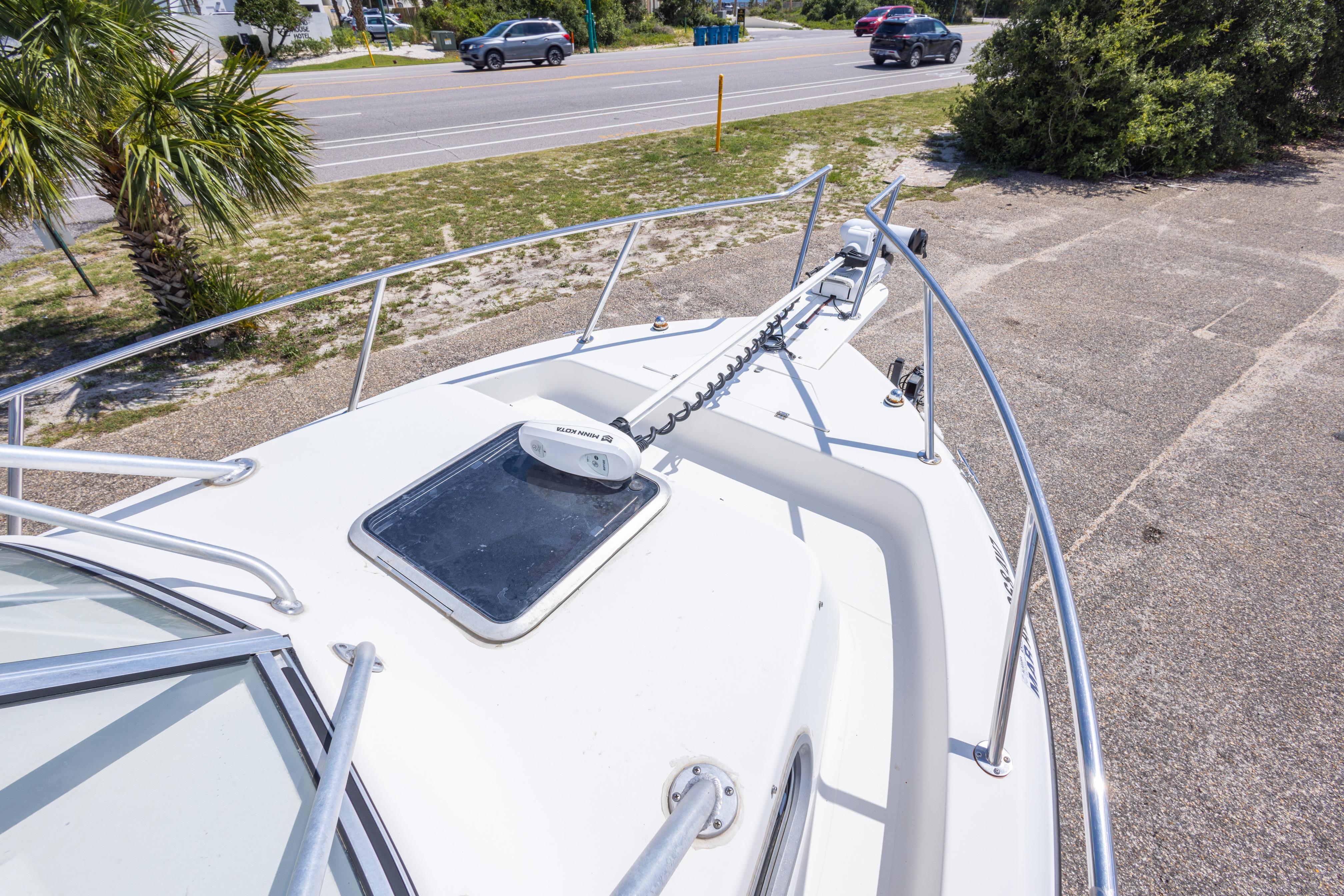 2007 Sea Boss 235 Walkaround boat on a sunny day, parked near a road.