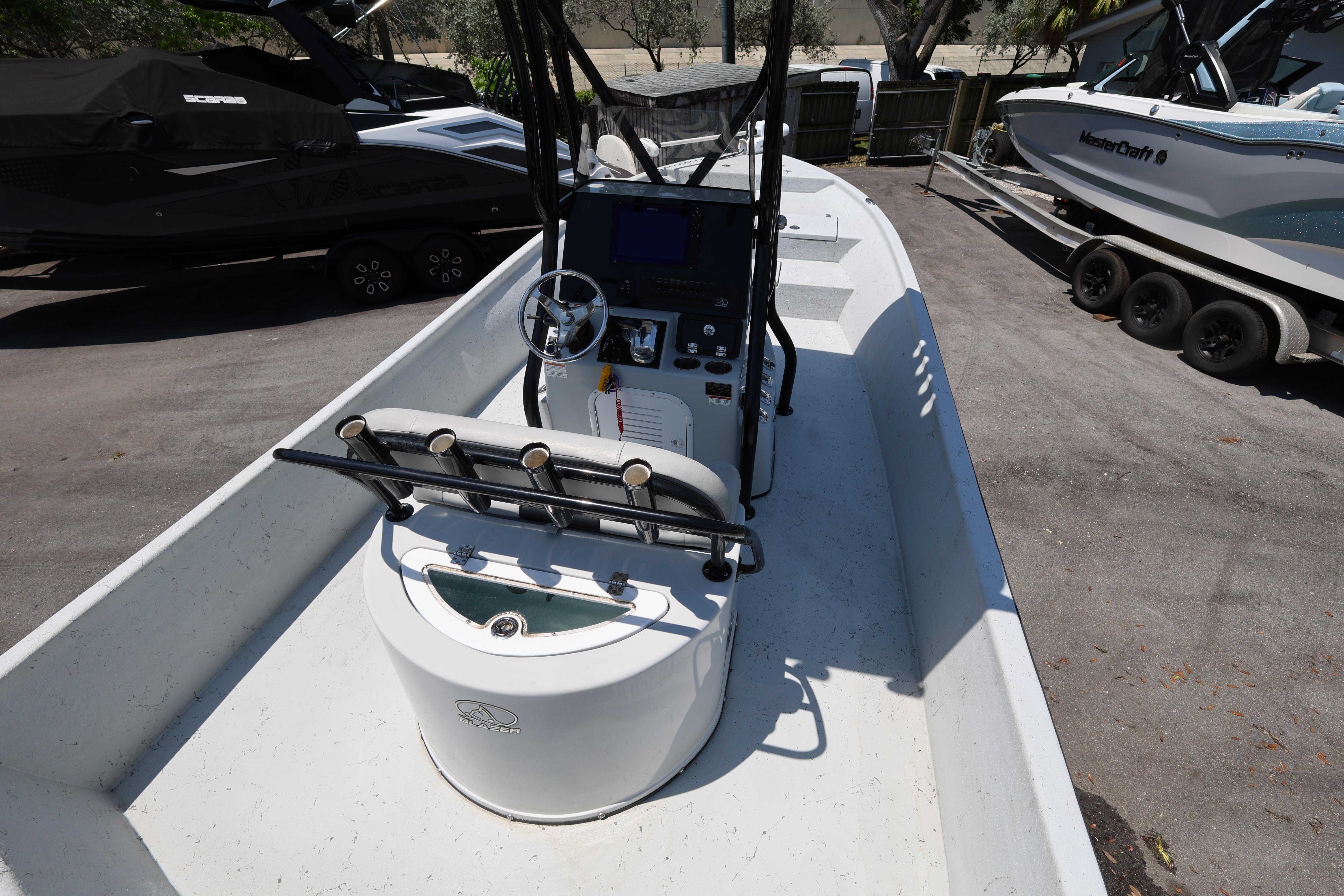2021 Blazer Bay 2400 boat interior with steering console and rod holders.