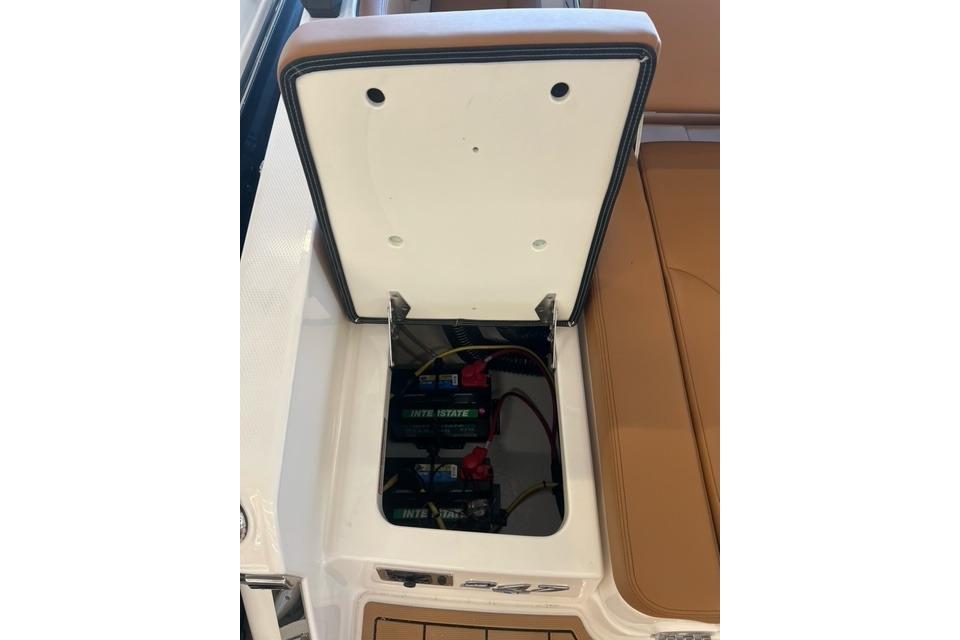 Open battery compartment of 2025 Chaparral 247 SSX boat, showcasing interior components.