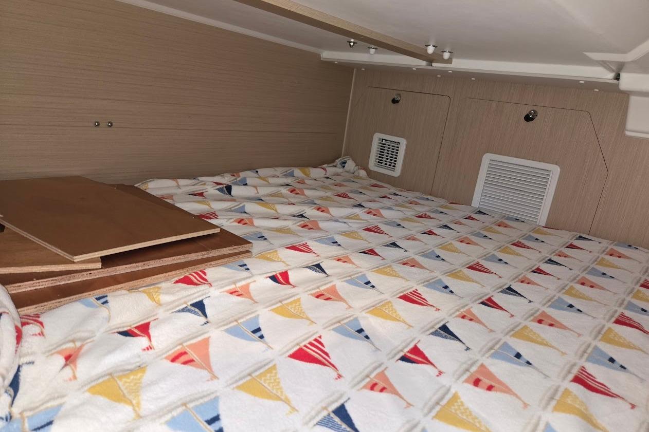 Cozy cabin interior of 2023 Beneteau Oceanis 38.1 with colorful patterned bedding.