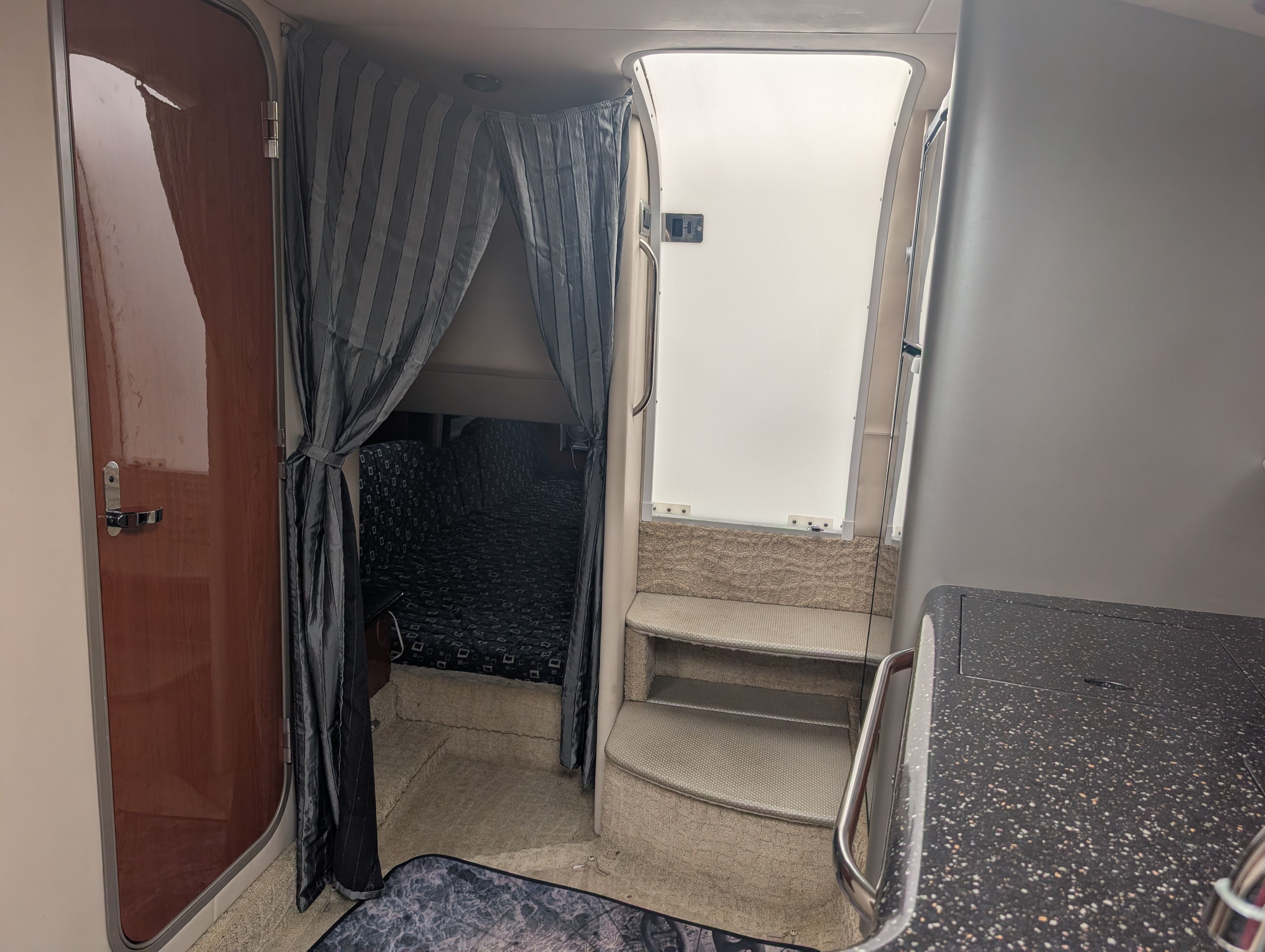 Interior of a 2007 Formula 400 Super Sport with curtains, stairs, and a small cabin.