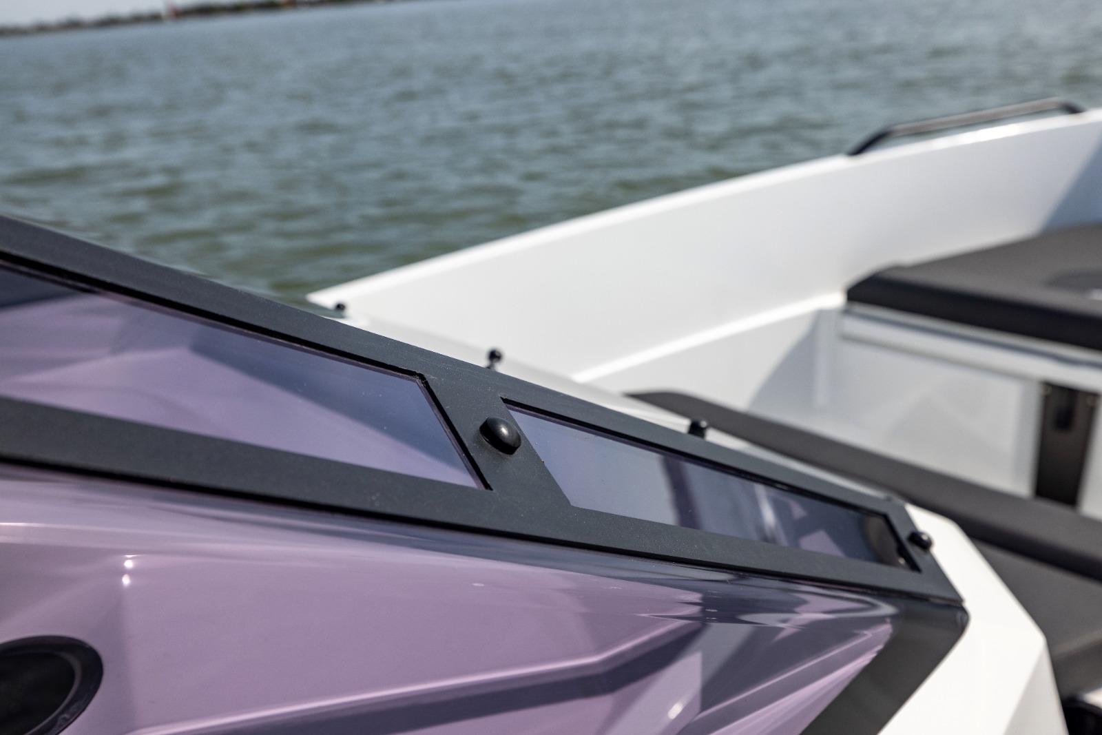 Close-up of Iron 707 boat's sleek design and windshield, 2022 model, on calm water.