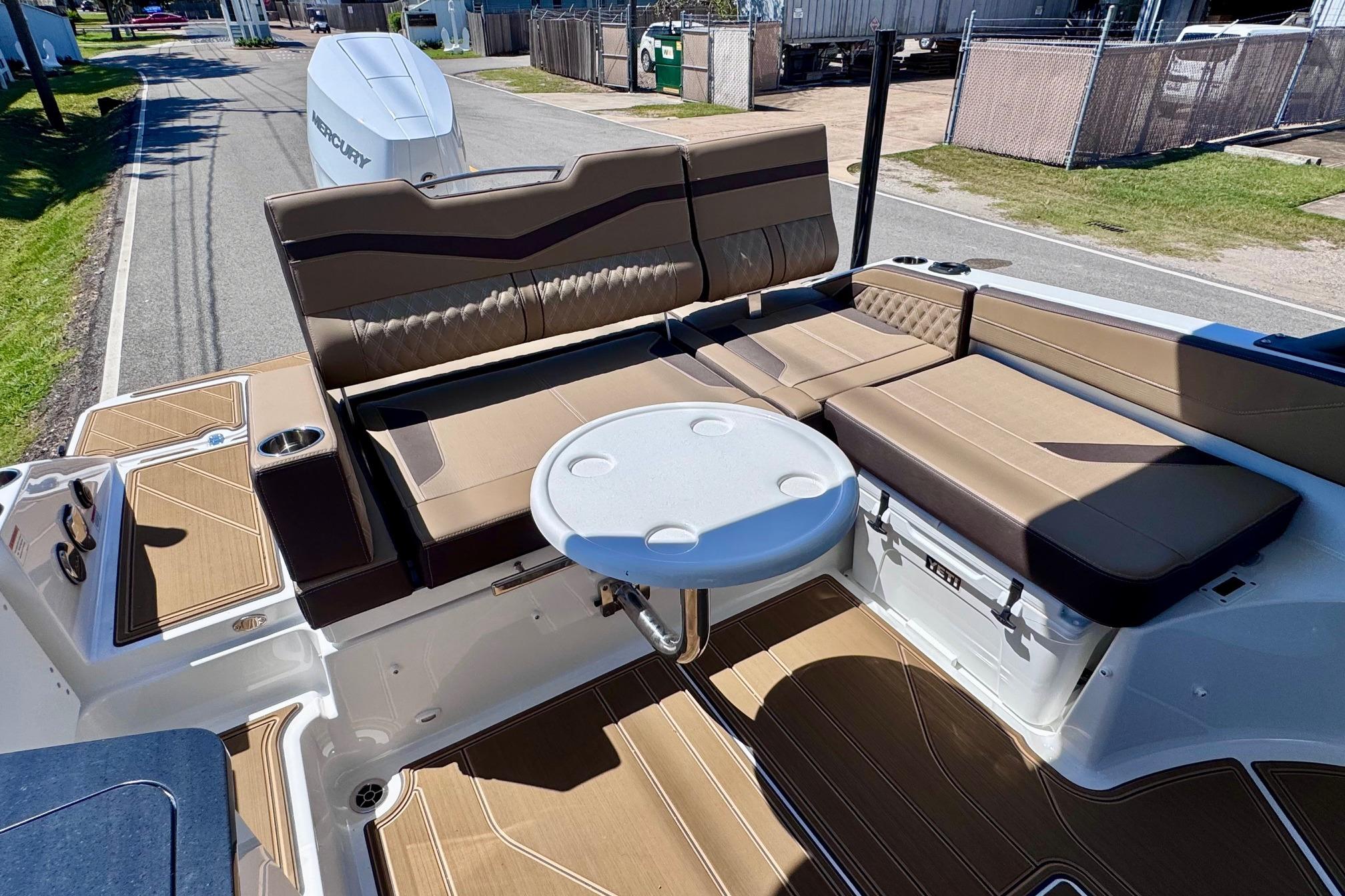 2026 Monterey Elite 27 OB boat interior with brown seating and round table.