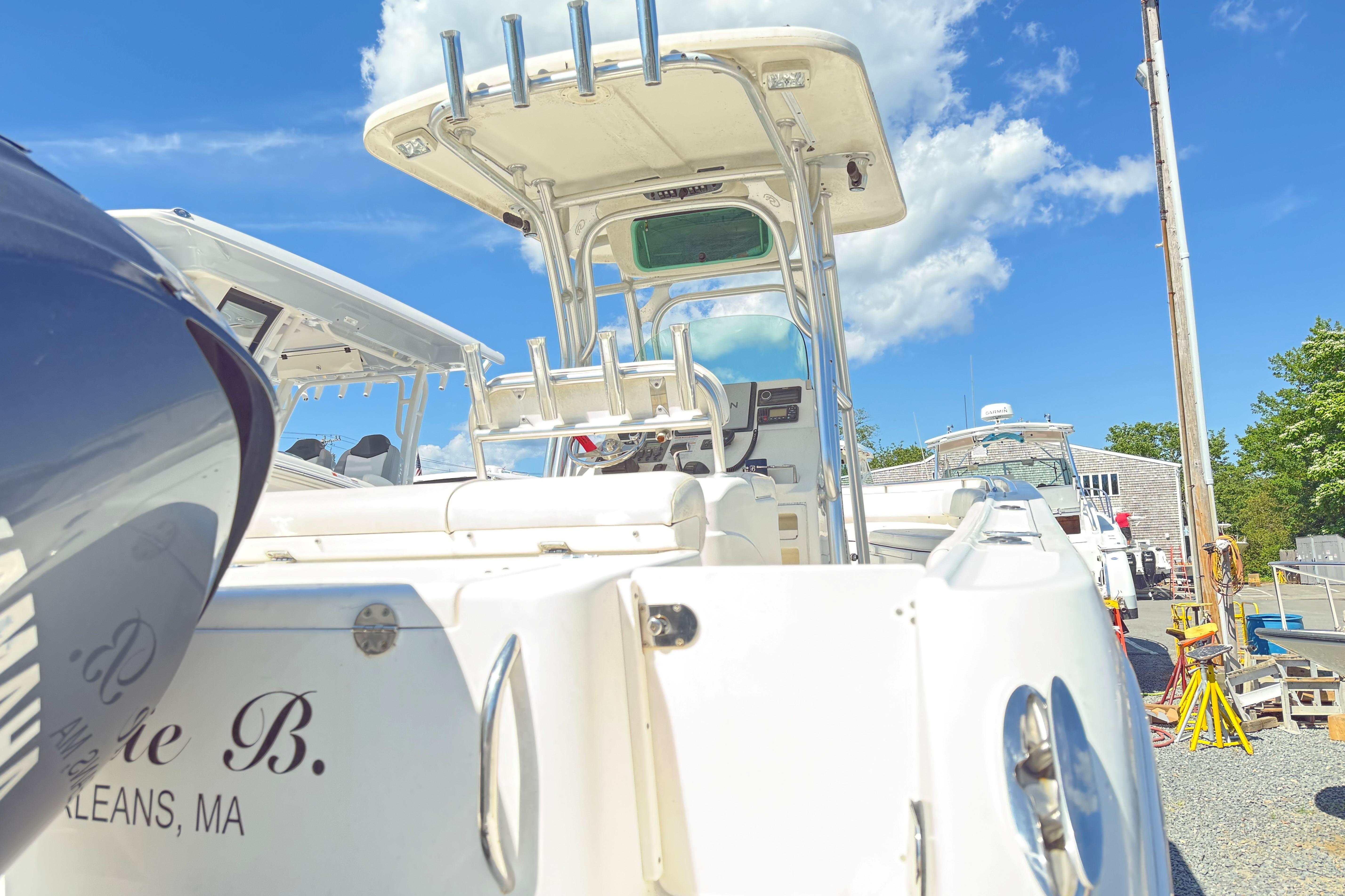 2009 Robalo R240 Center Console boat docked under a clear blue sky.