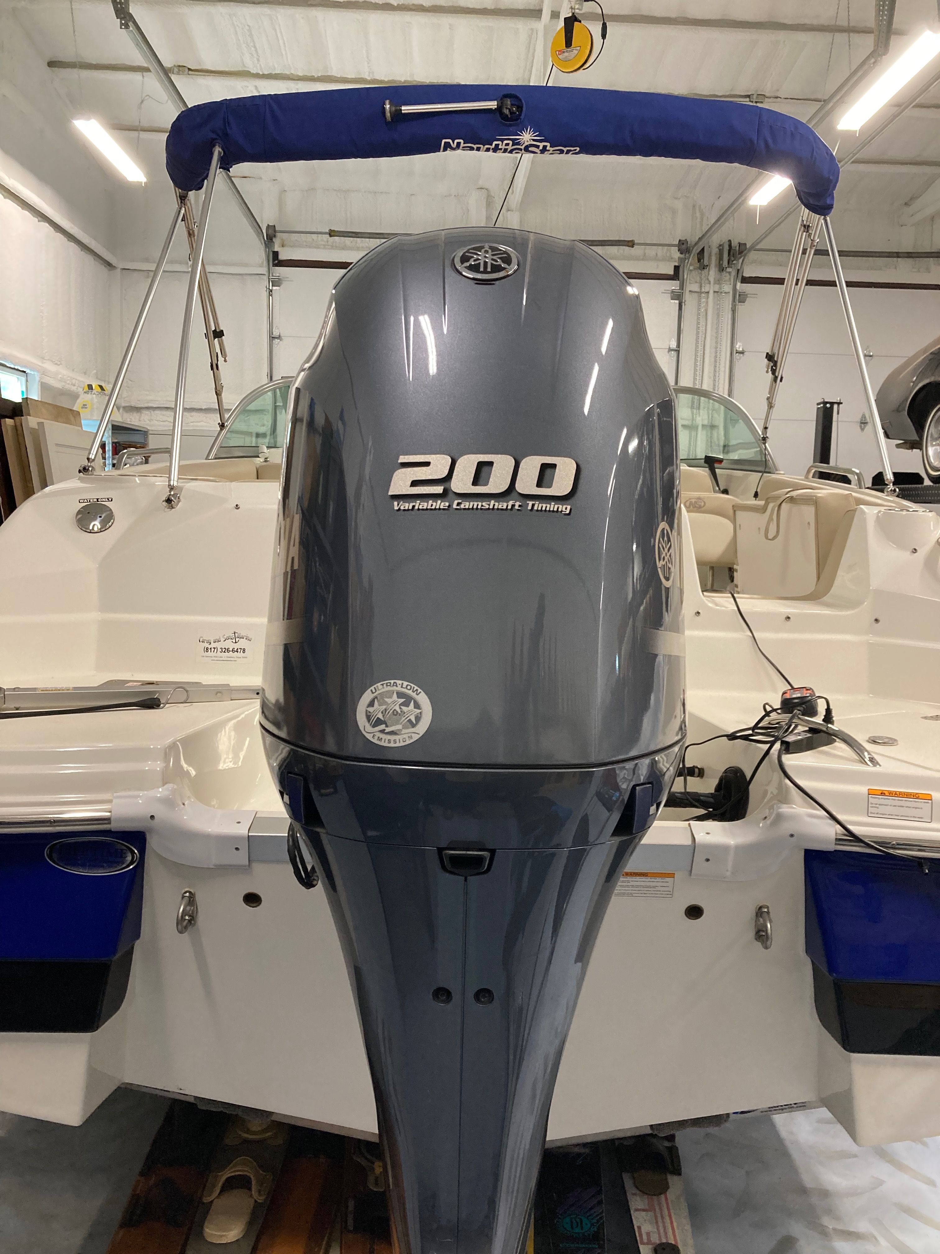 Outboard motor of a boat with blue canopy and seating area.