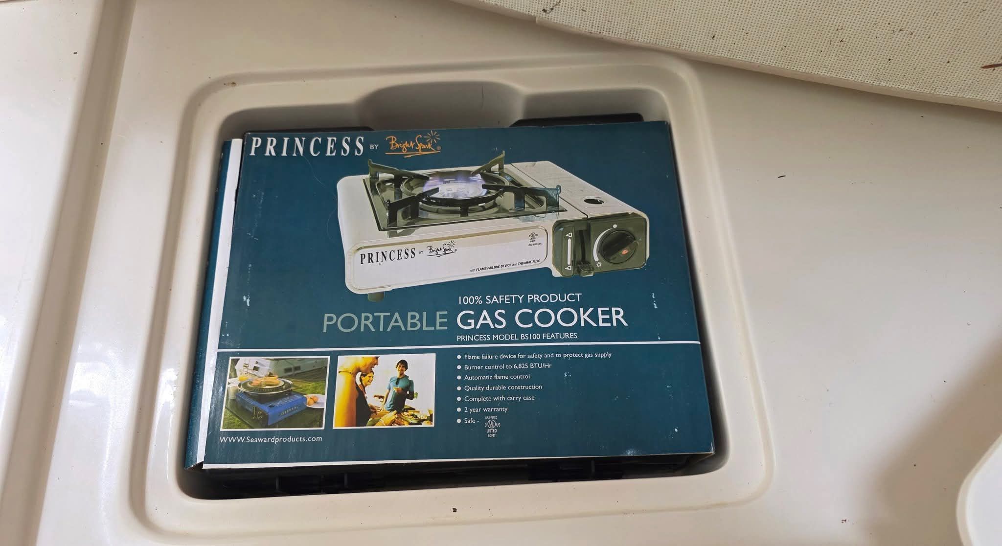 Portable gas cooker in a boat storage compartment.