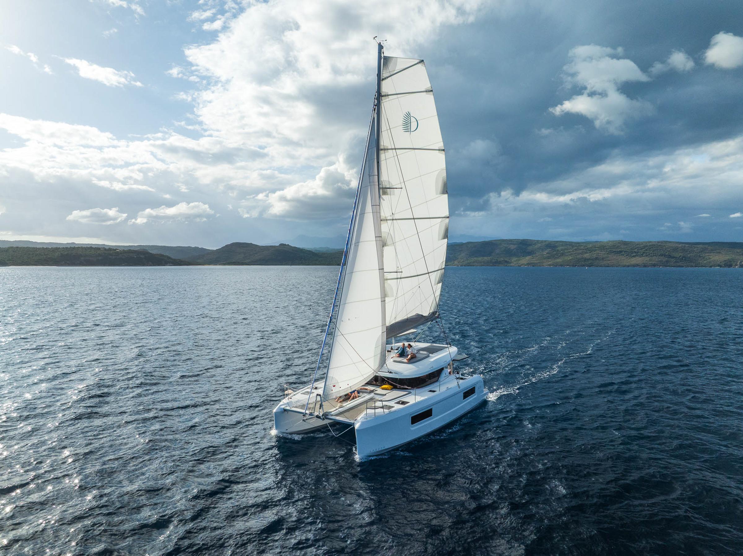 Sailing Lagoon 38 catamaran on open sea under cloudy sky, 2025 model.