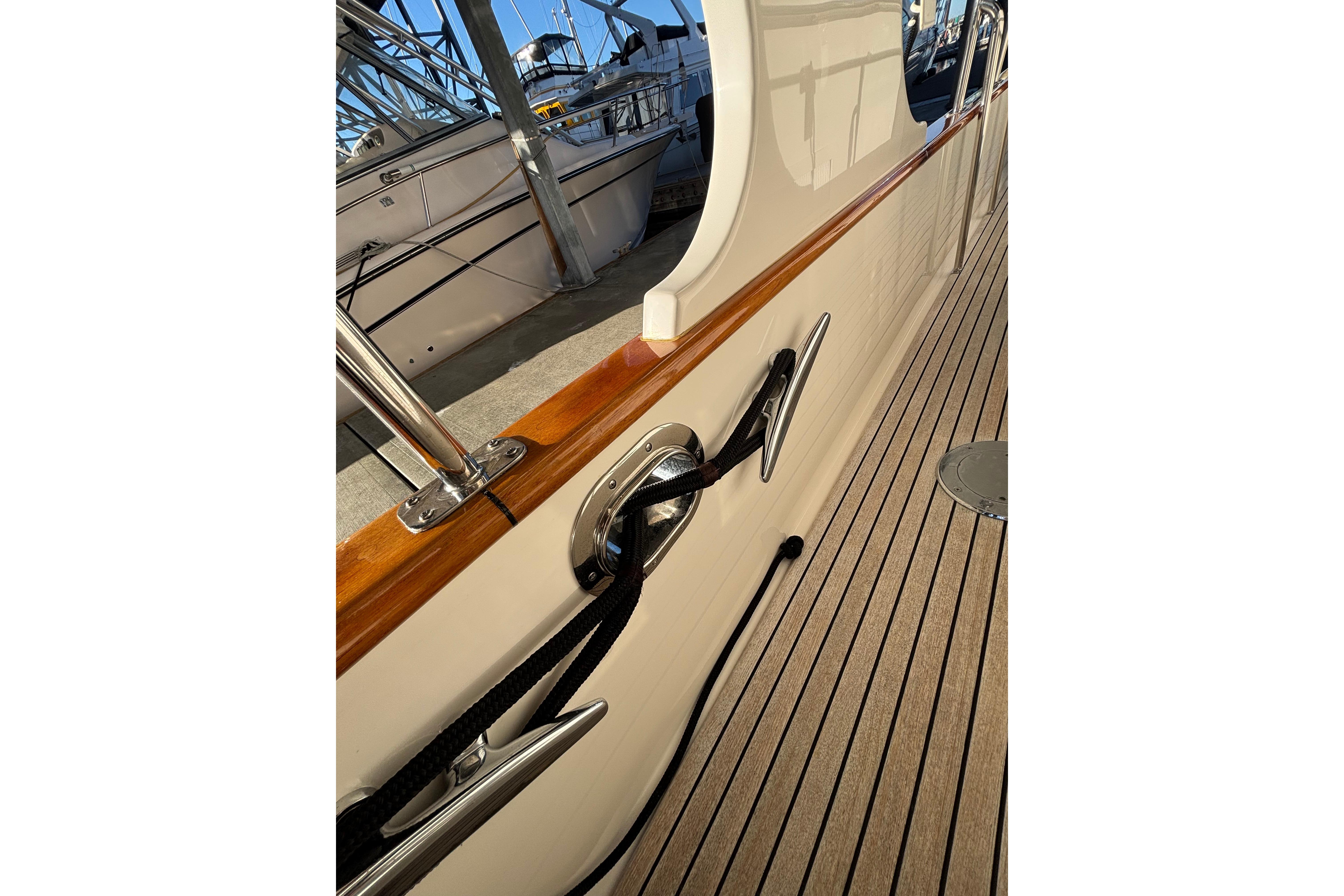 2006 Grand Banks 47 Heritage EU yacht deck with polished wood and secure mooring line.