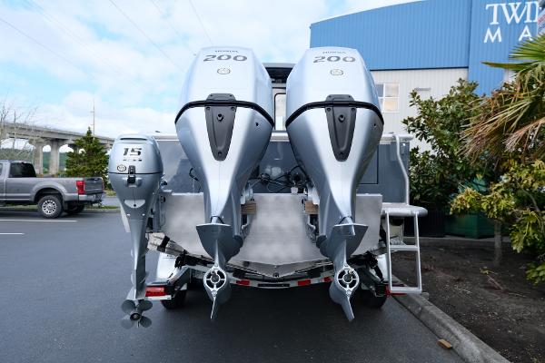 2024 Hewescraft 250 Explorer with triple outboard motors in a parking lot.