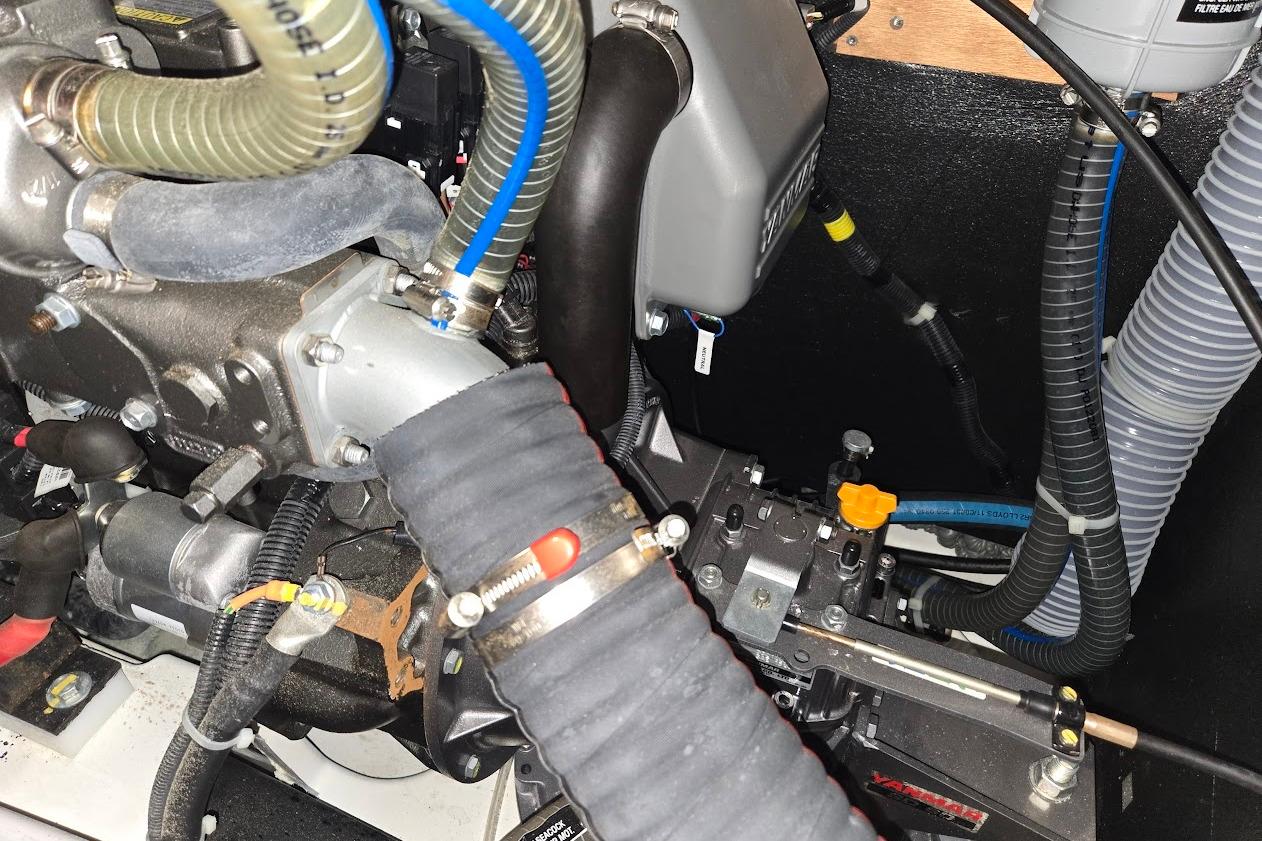 Engine compartment of a 2023 Beneteau Oceanis 38.1 sailboat, showcasing hoses and mechanical components.
