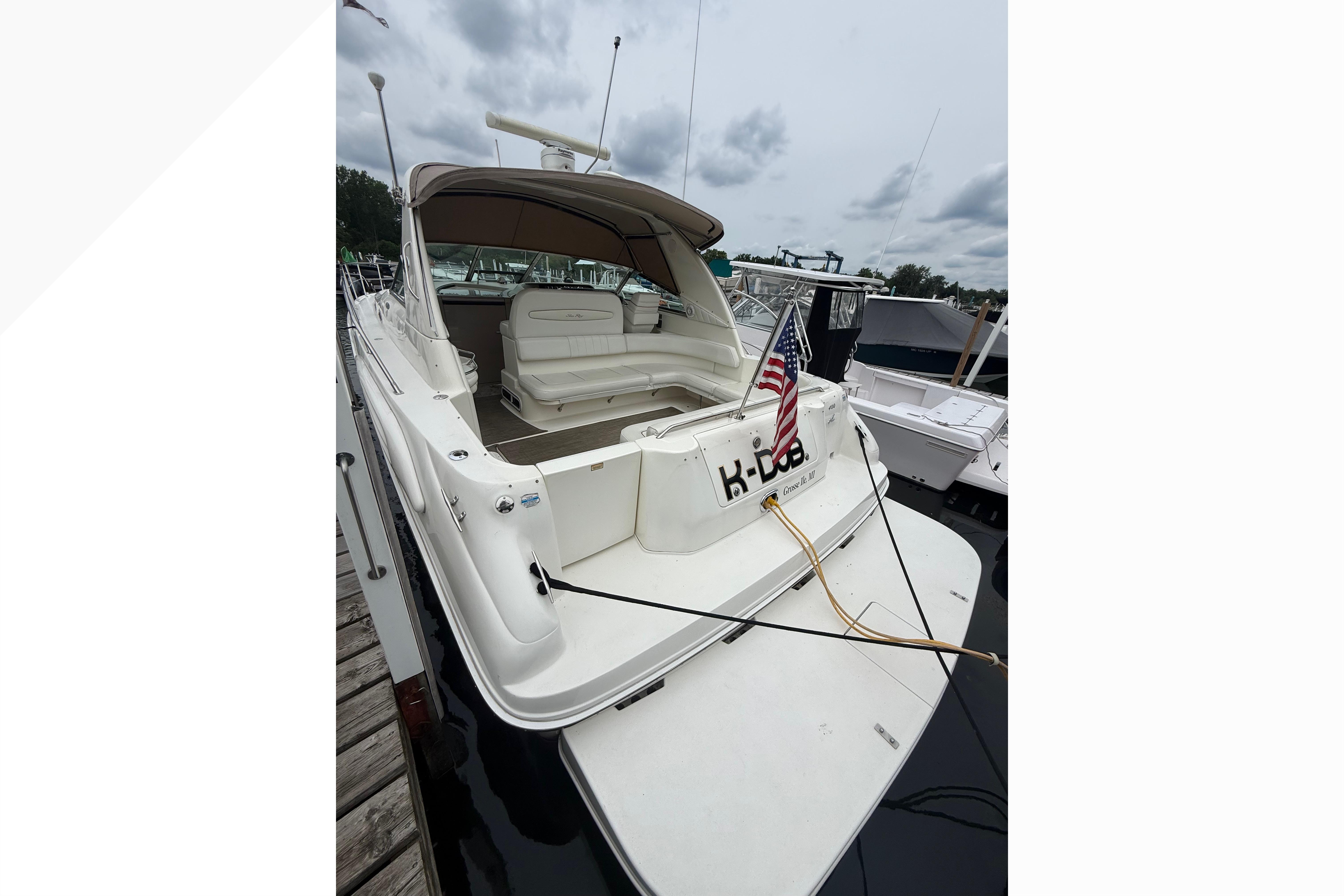 1998 Sea Ray Sundancer 400 yacht docked, featuring spacious seating and American flag.