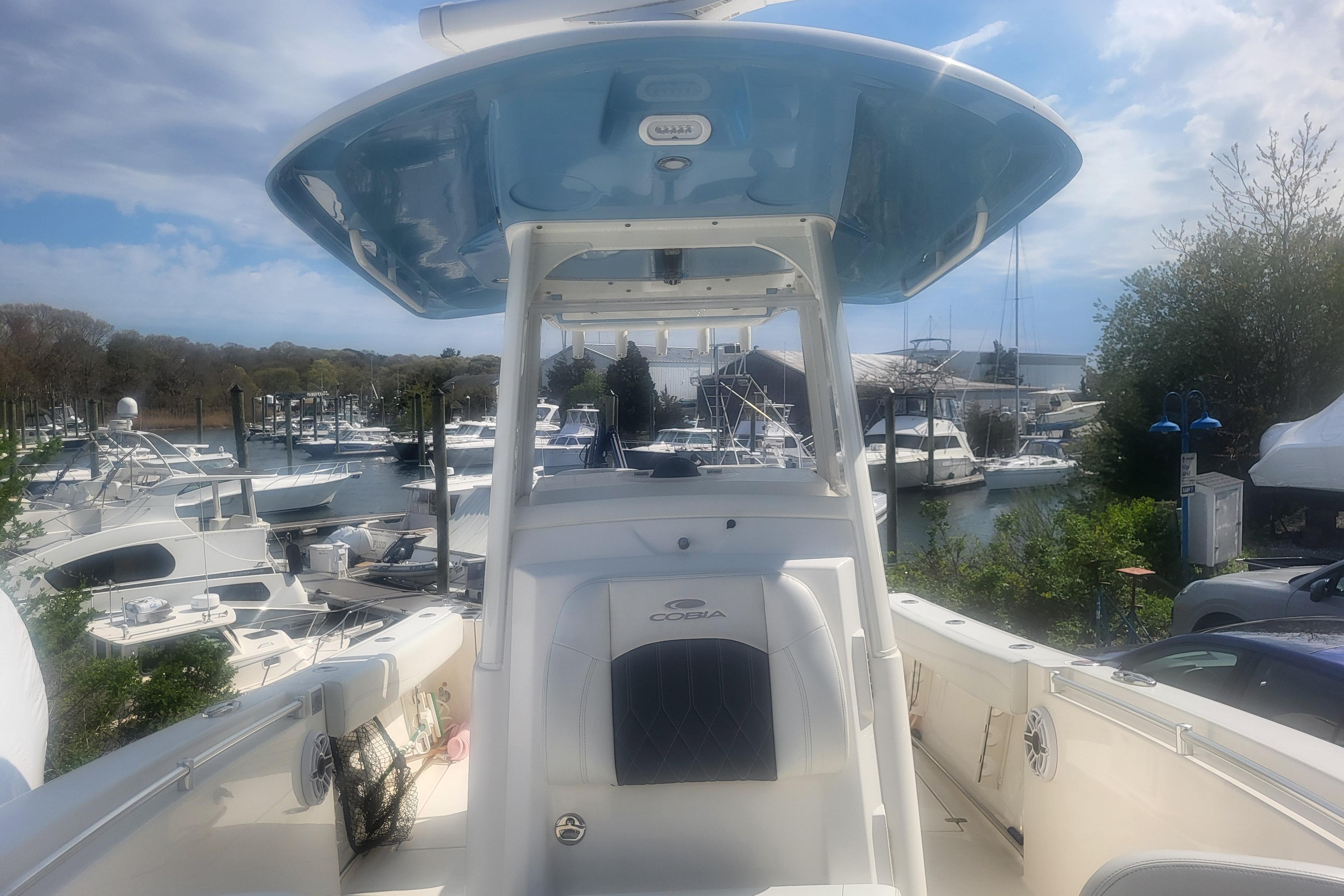 2022 Cobia 262 Center Console boat docked at a marina under a partly cloudy sky.