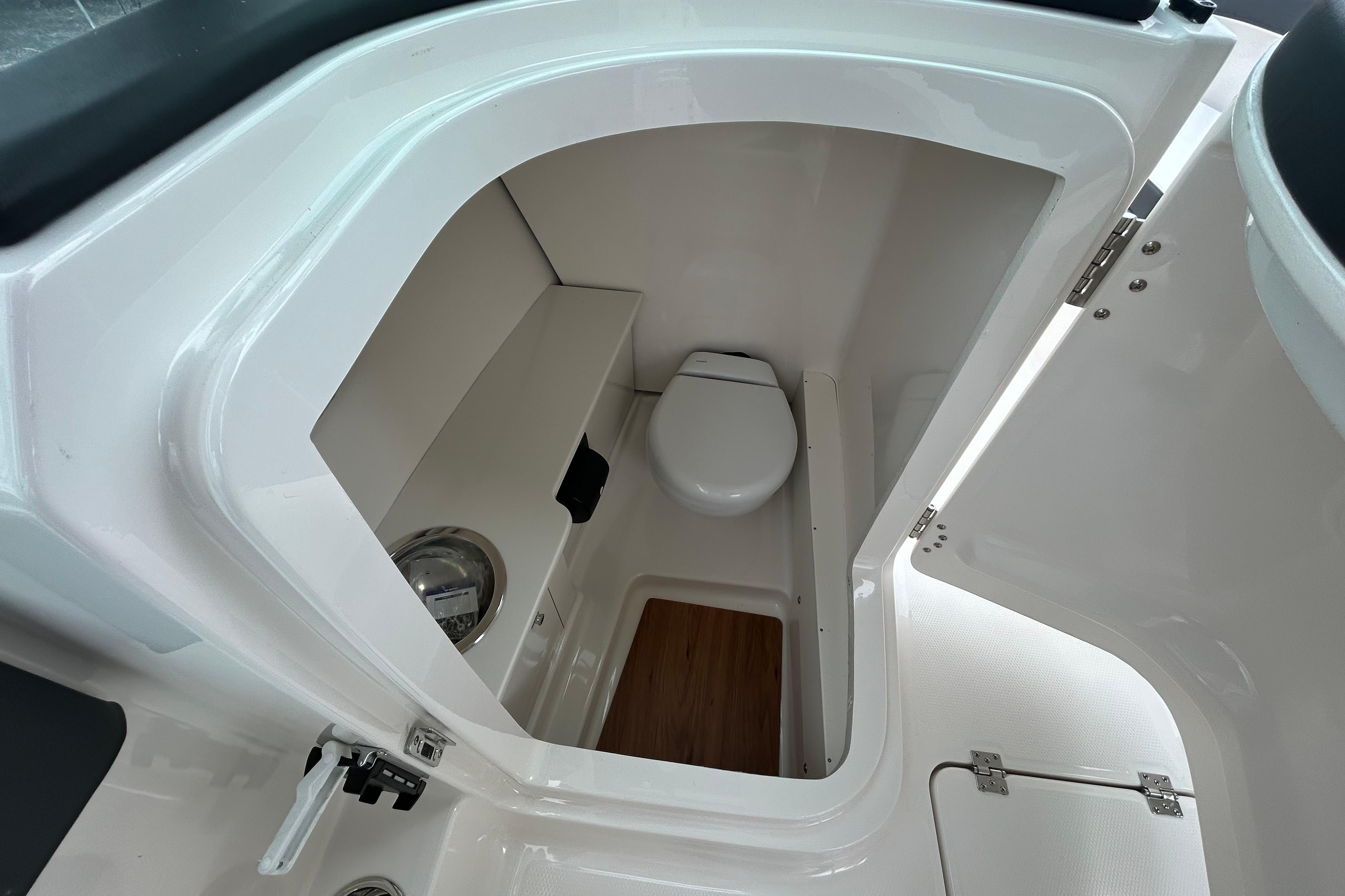 2026 Robalo R257 Dual Console boat interior with compact marine toilet.