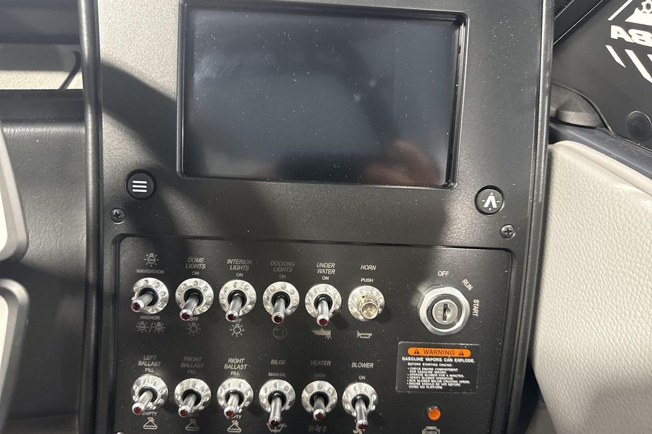 Dashboard of a Moomba Craz boat with switches and a screen.