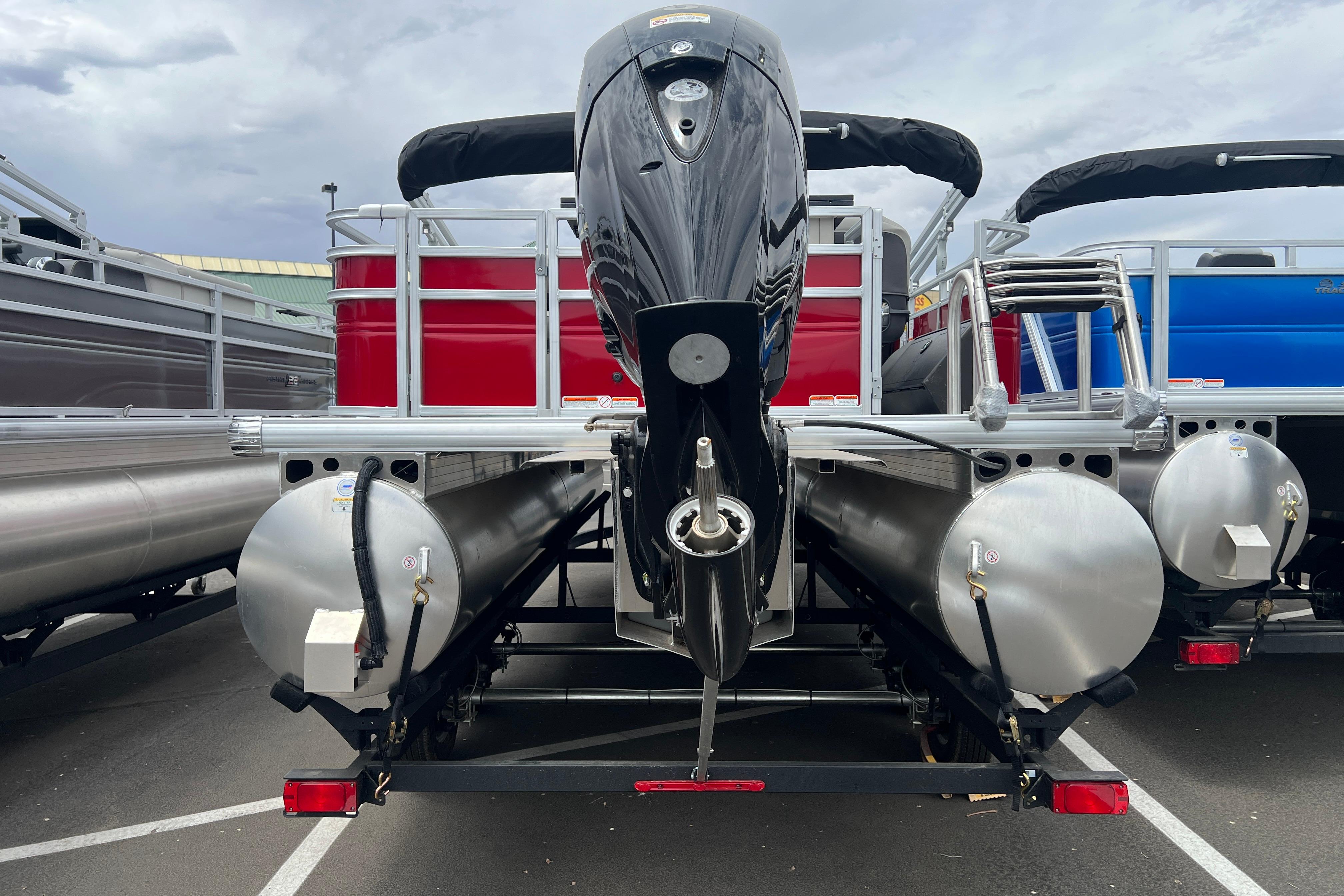 2026 Sun Tracker Fishin' Barge 22 DLX pontoon boat, rear view with motor and pontoons.