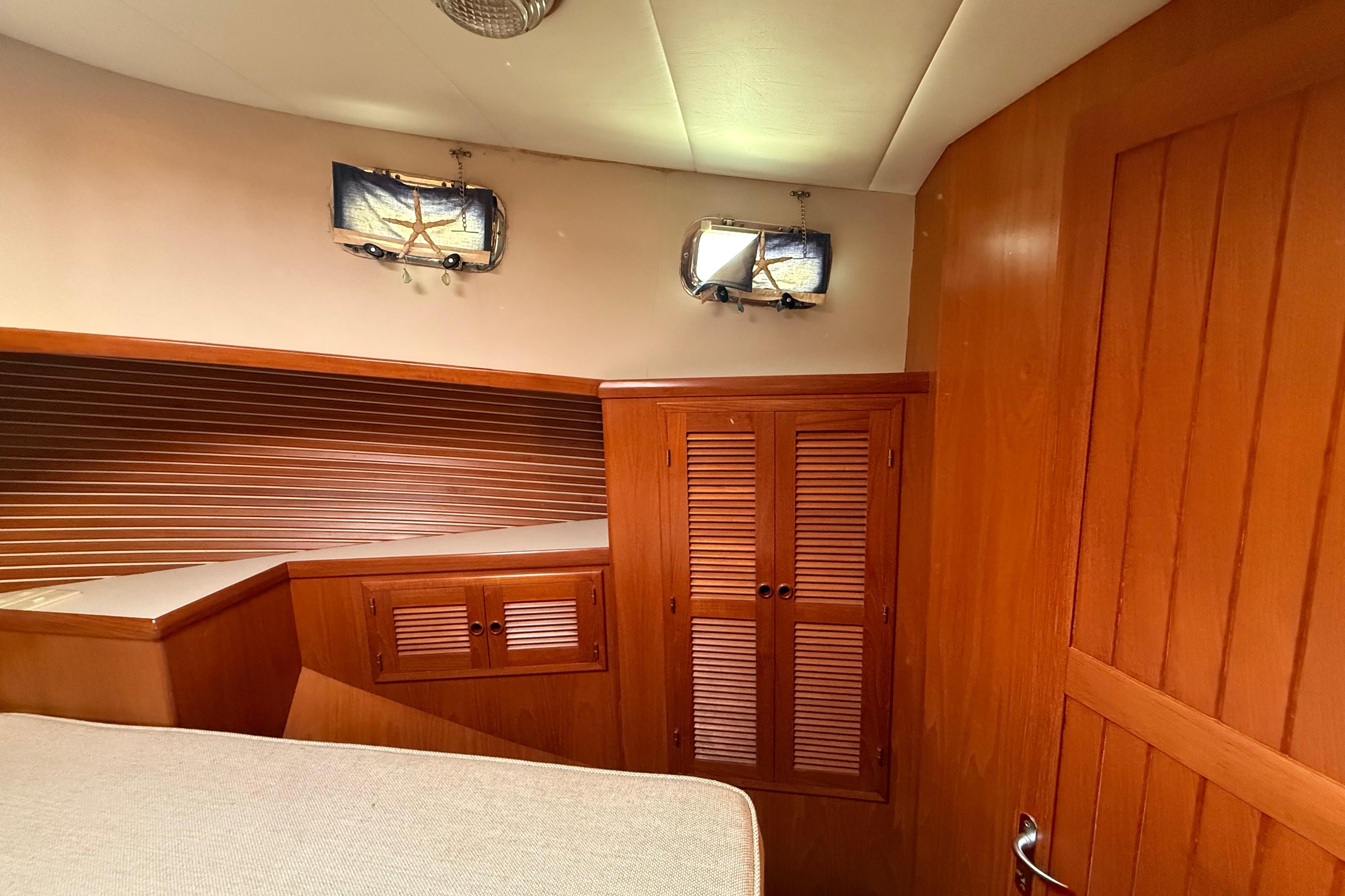 Cozy wooden interior of a 2001 Kadey-Krogen 39 yacht cabin with storage cabinets.