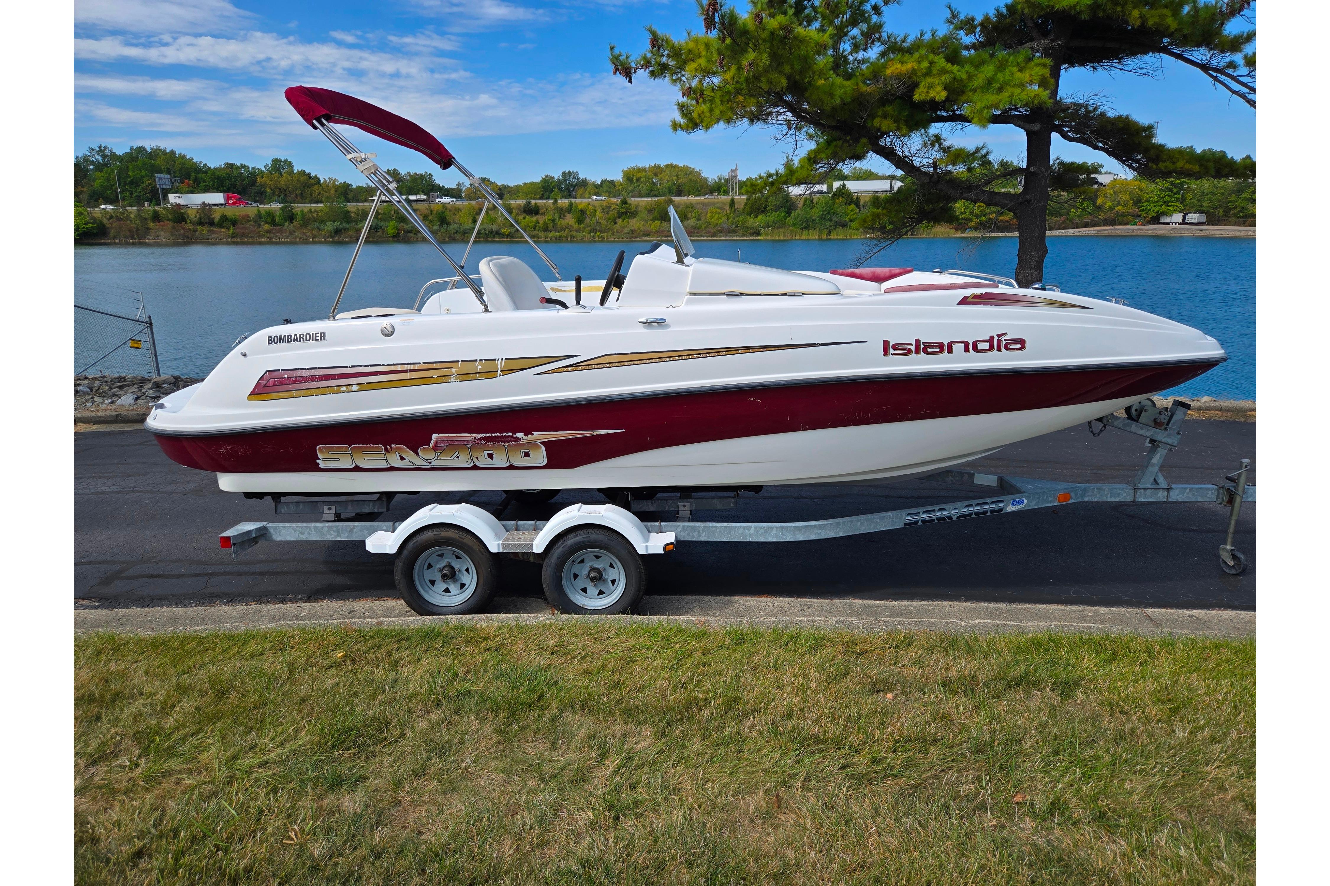 2004 Sea-Doo Islandia boat on trailer by a scenic lake.